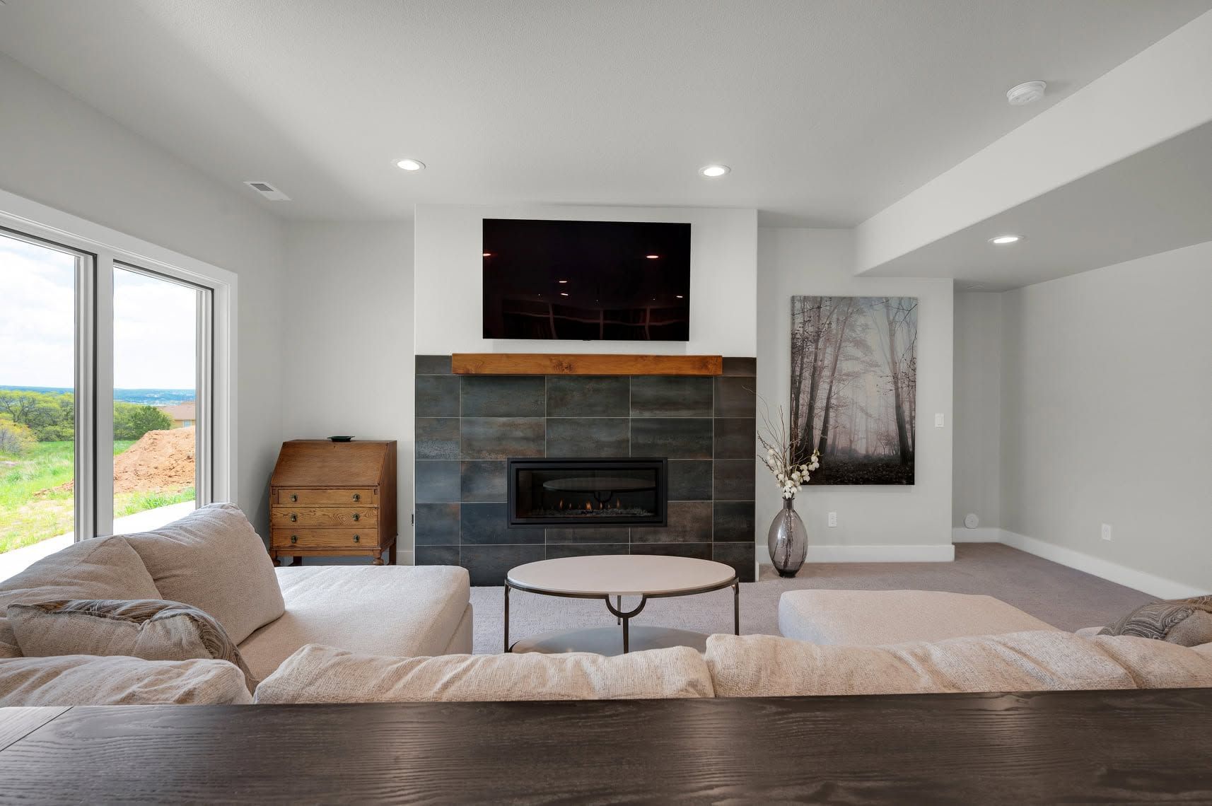 Bright kitchen with wood floors, white cabinetry, granite counters, and a stainless steel refrigerator and oven.