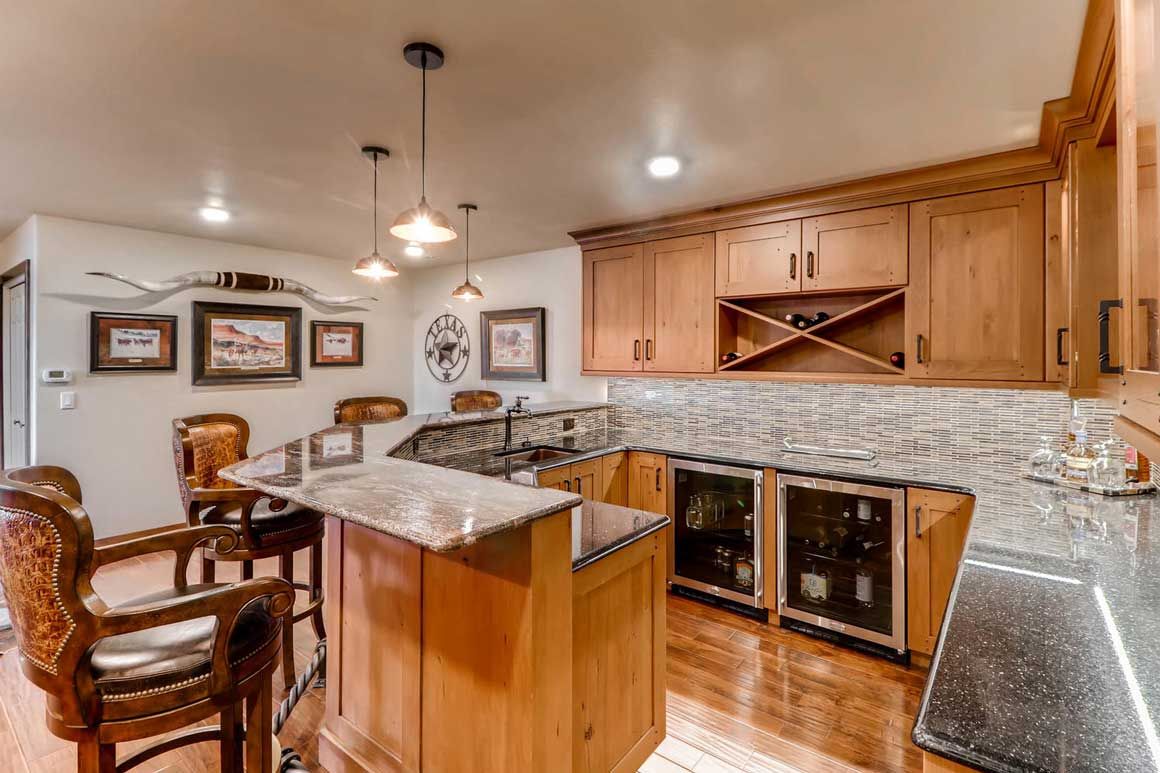 Bright open-concept kitchen and living room with large windows, vaulted ceiling, and modern furnishings