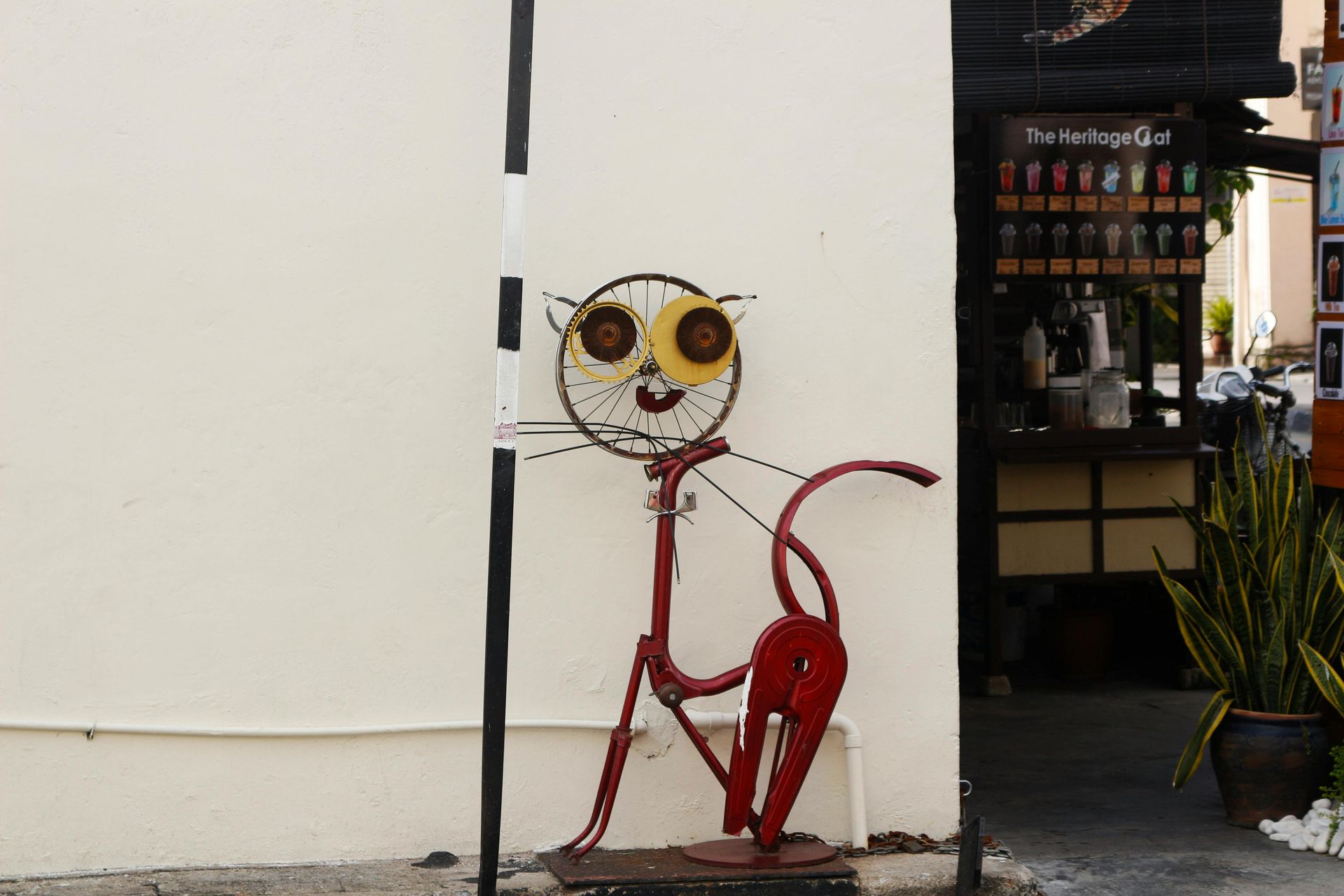 Una estatua de un gato está pintada en el costado de un edificio.