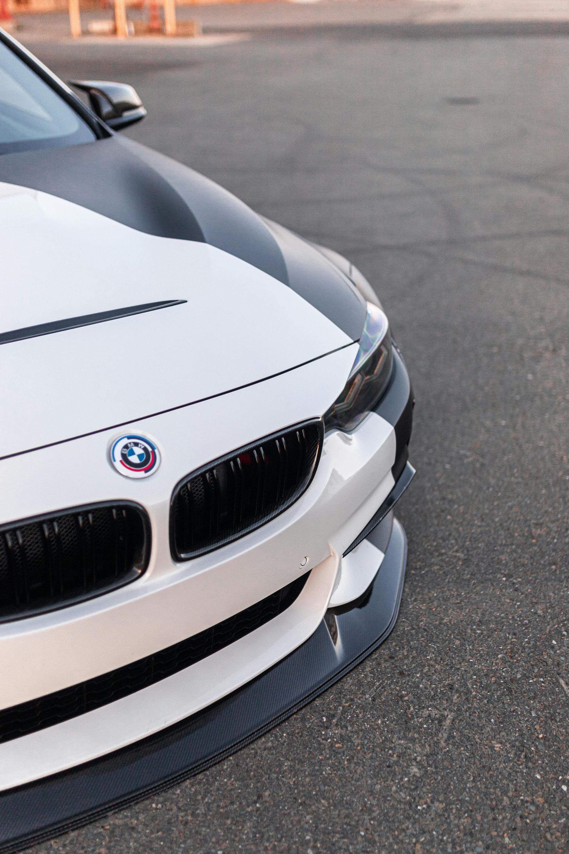A white and black bmw is parked on the street.