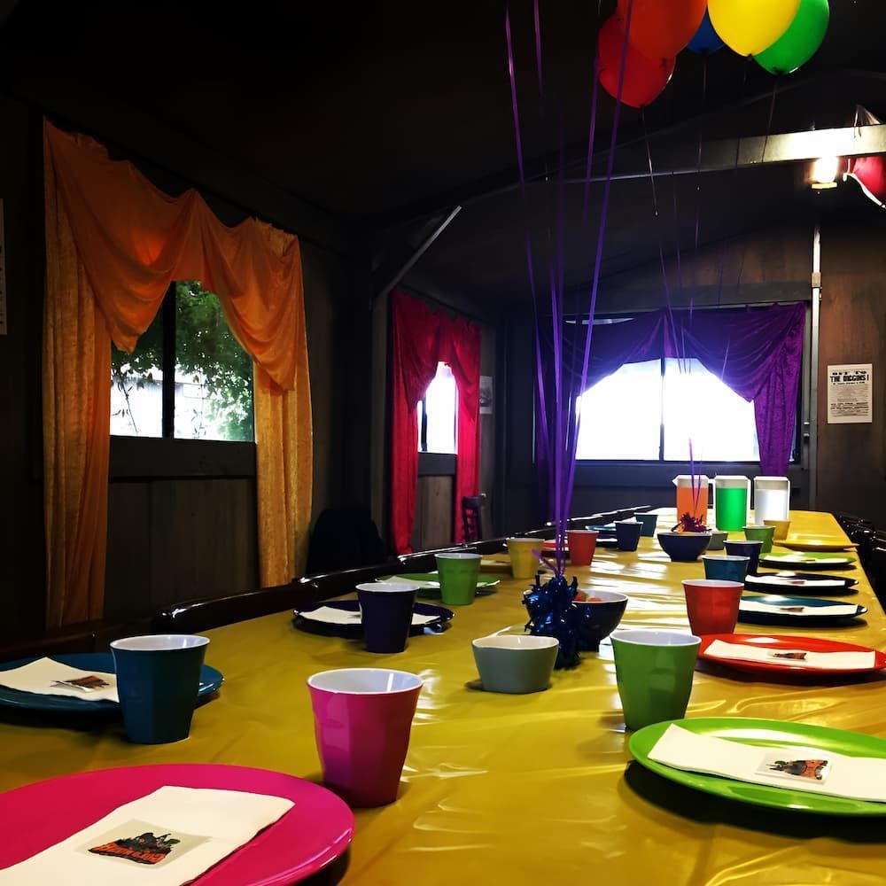 A Long Table With Plates and Cups and Balloons Hanging From the Ceiling — Gold Rush Mini Golf in Warrenheip, VIC