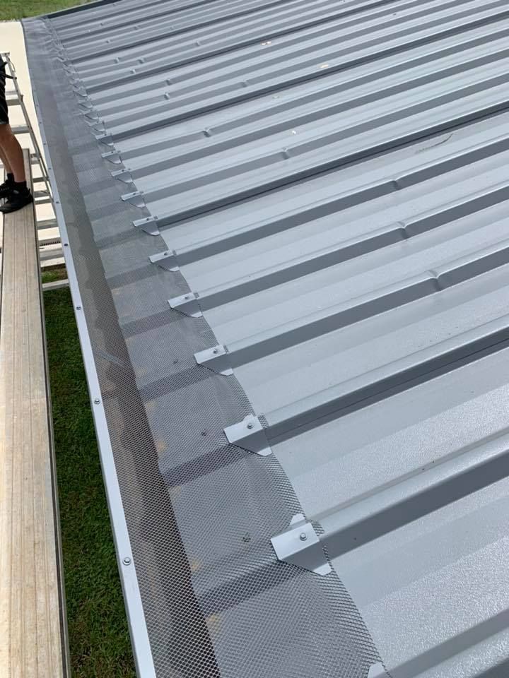 Grey metal roof with black mesh gutter guard, viewed from above.— Gutter Guard In Taree, NSW