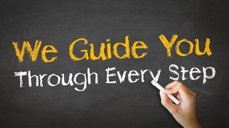 Handwriting on chalkboard: “We Guide You Through Every Step,” with a hand writing the last words