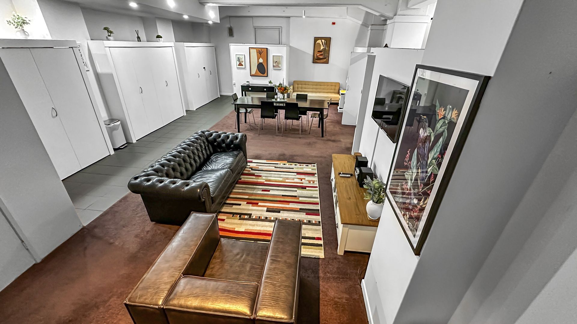Lobby with living room, dining area, artwork, and white storage cabinets.