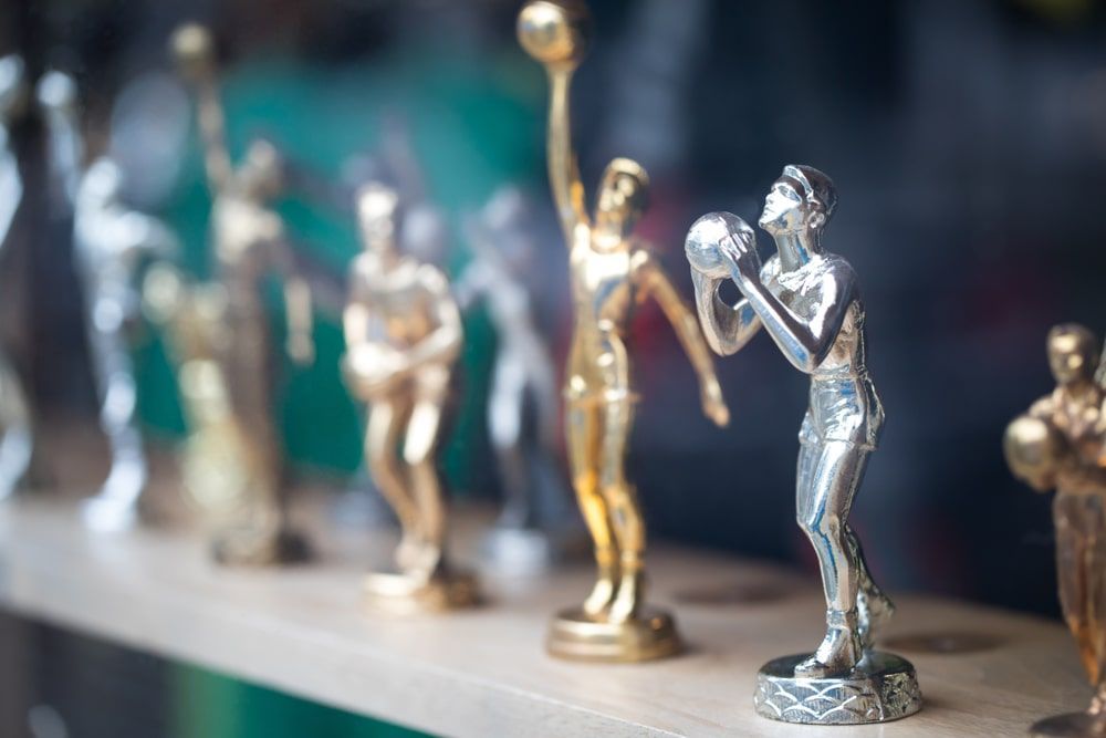 Row Of Trophies On Top Of A Wooden Table — Accolades Awards Hunter Valley In Maitland, NSW