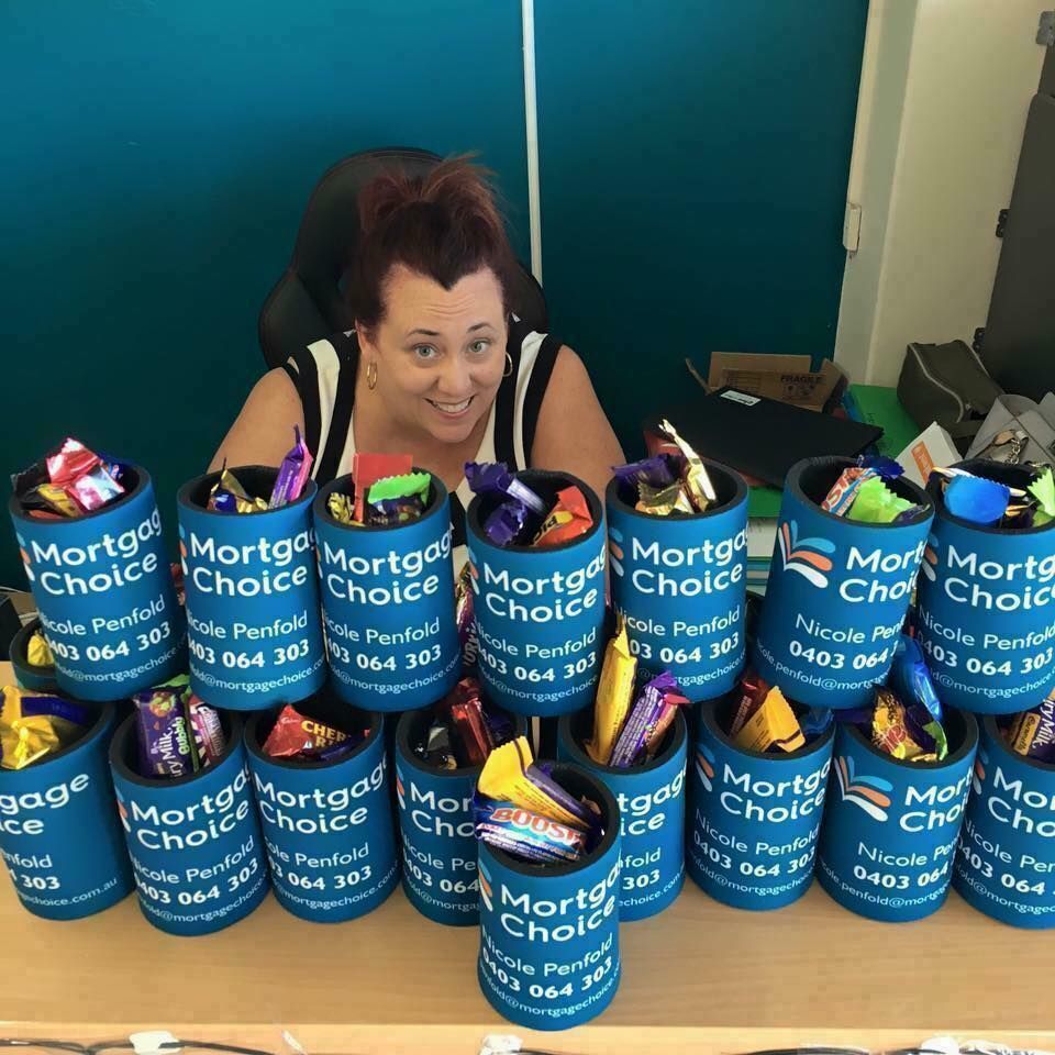 Woman Sits In Front Of A Table Full Of Mortgage Choice Cans — Accolades Awards Hunter Valley In Maitland, NSW
