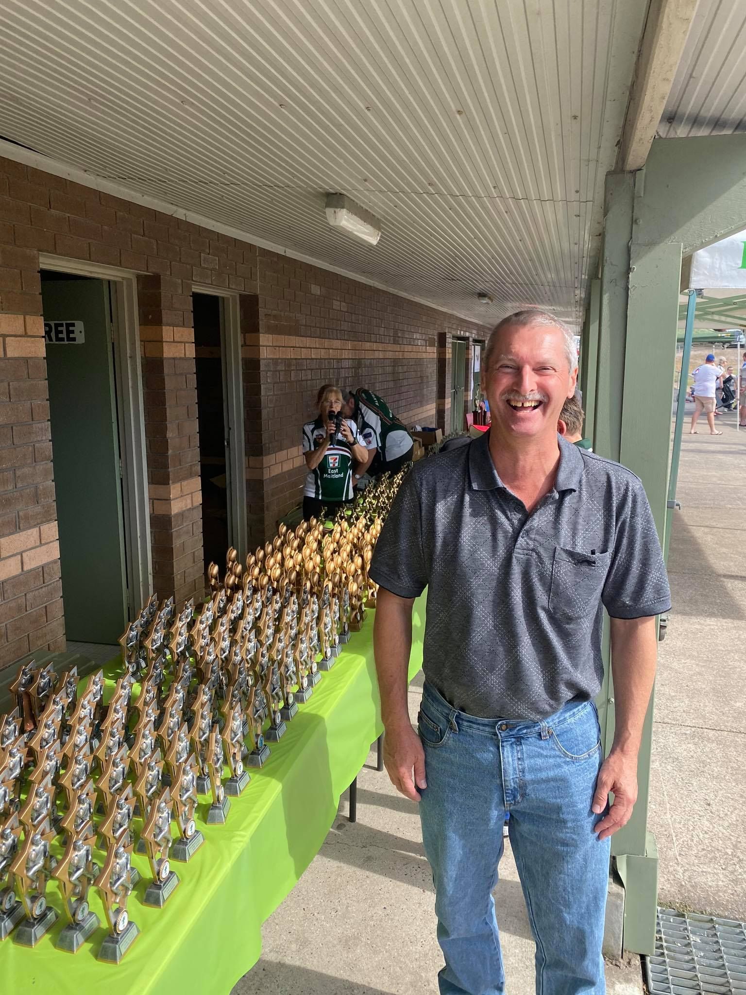Man Standing In Front Of A Table Full Of Trophies — Accolades Awards Hunter Valley In Maitland, NSW