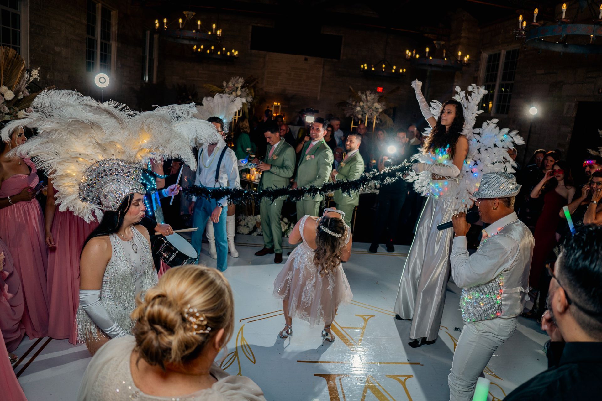 A group of people are dancing on a dance floor at a wedding reception.