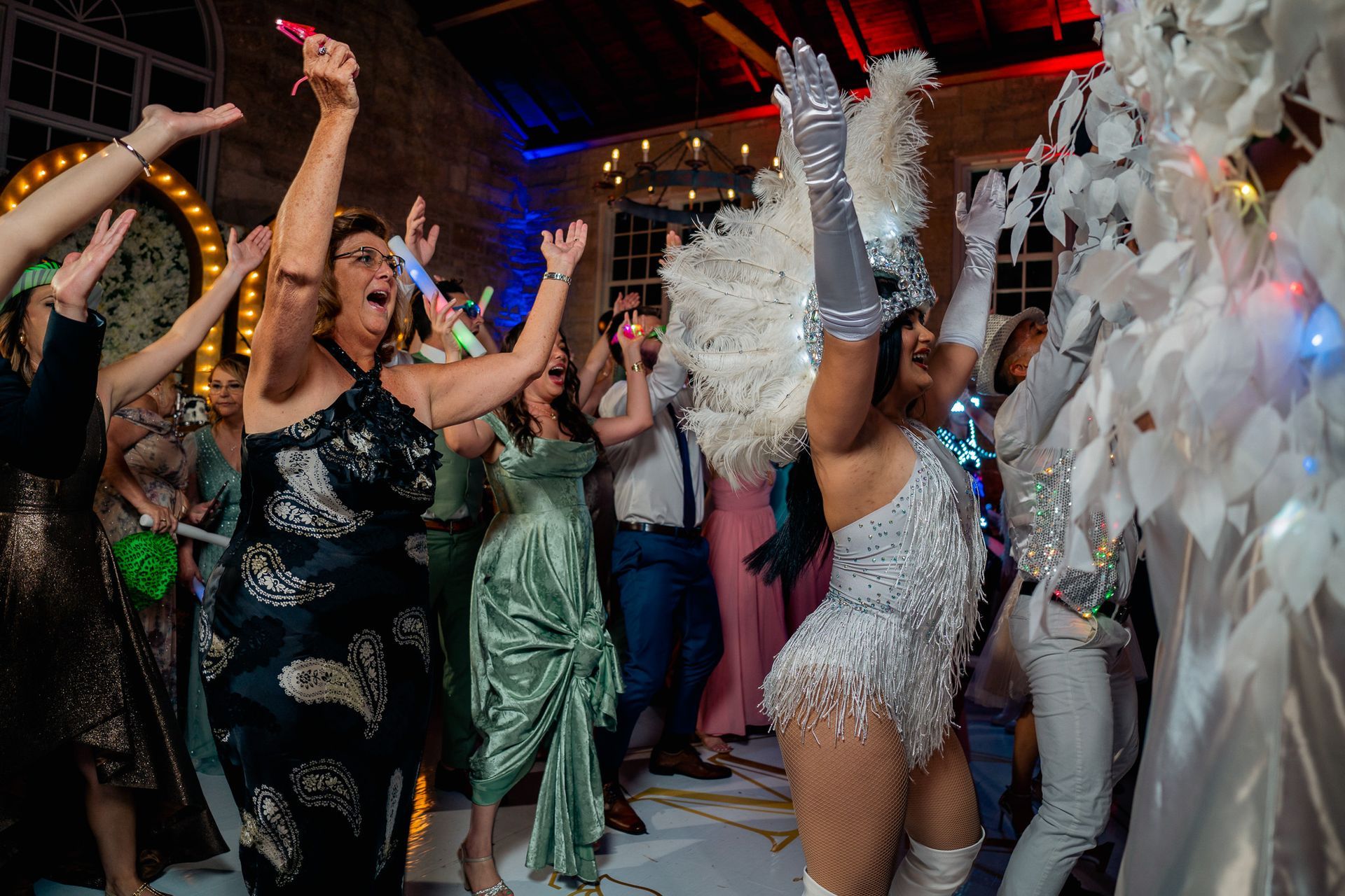 A group of people are dancing in a room at a party.