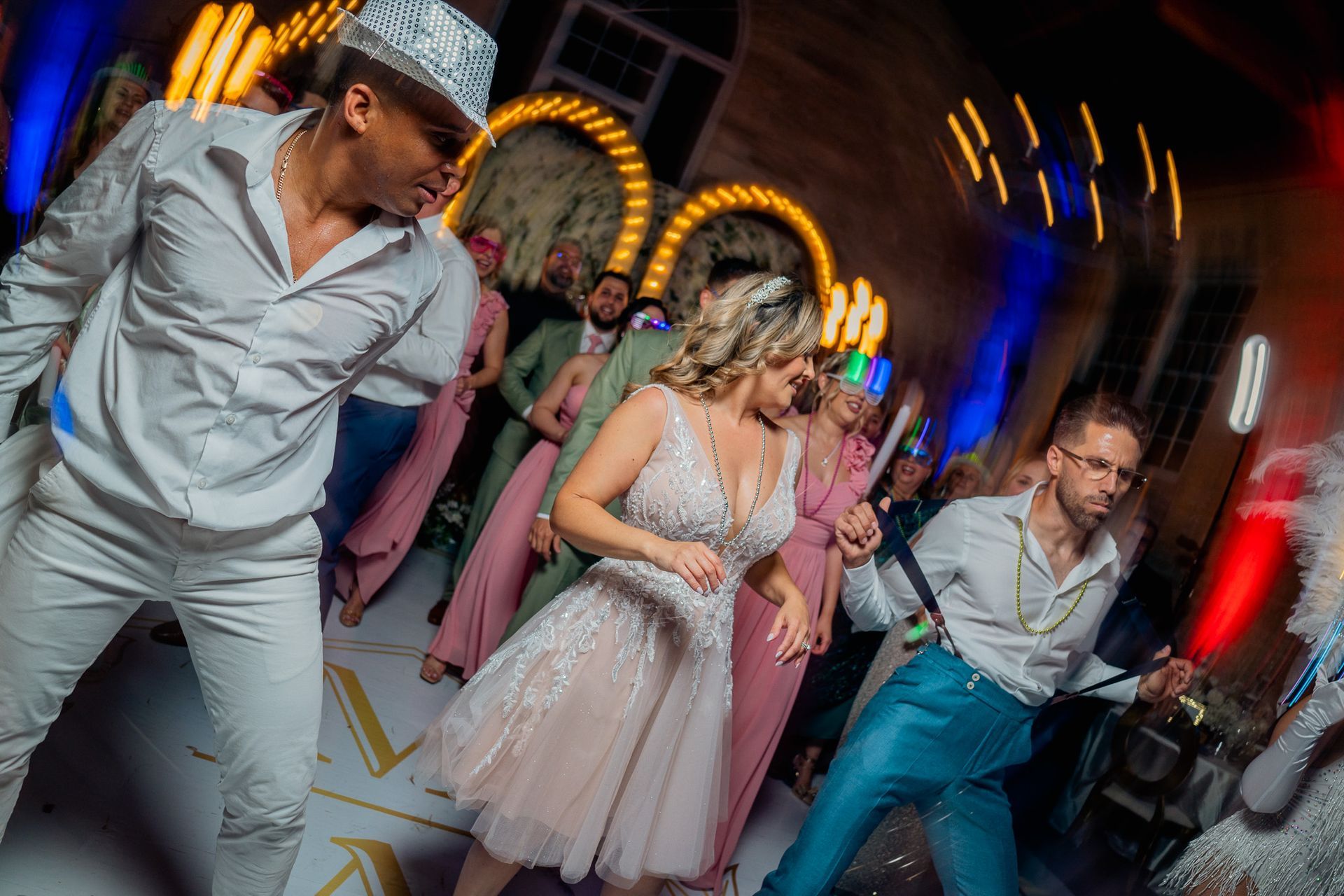 A group of people are dancing at a wedding reception.