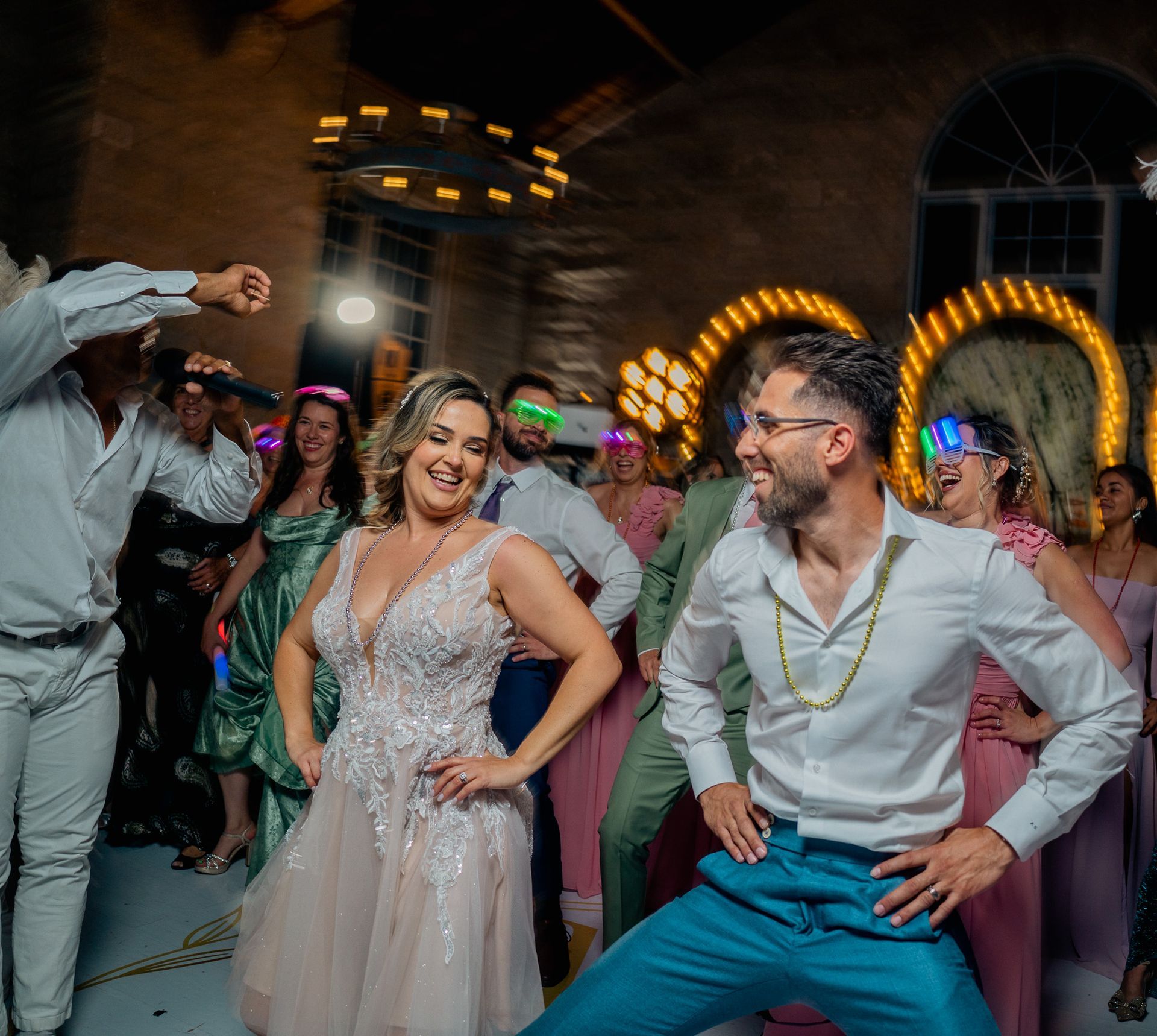 A group of people are dancing at a wedding reception.