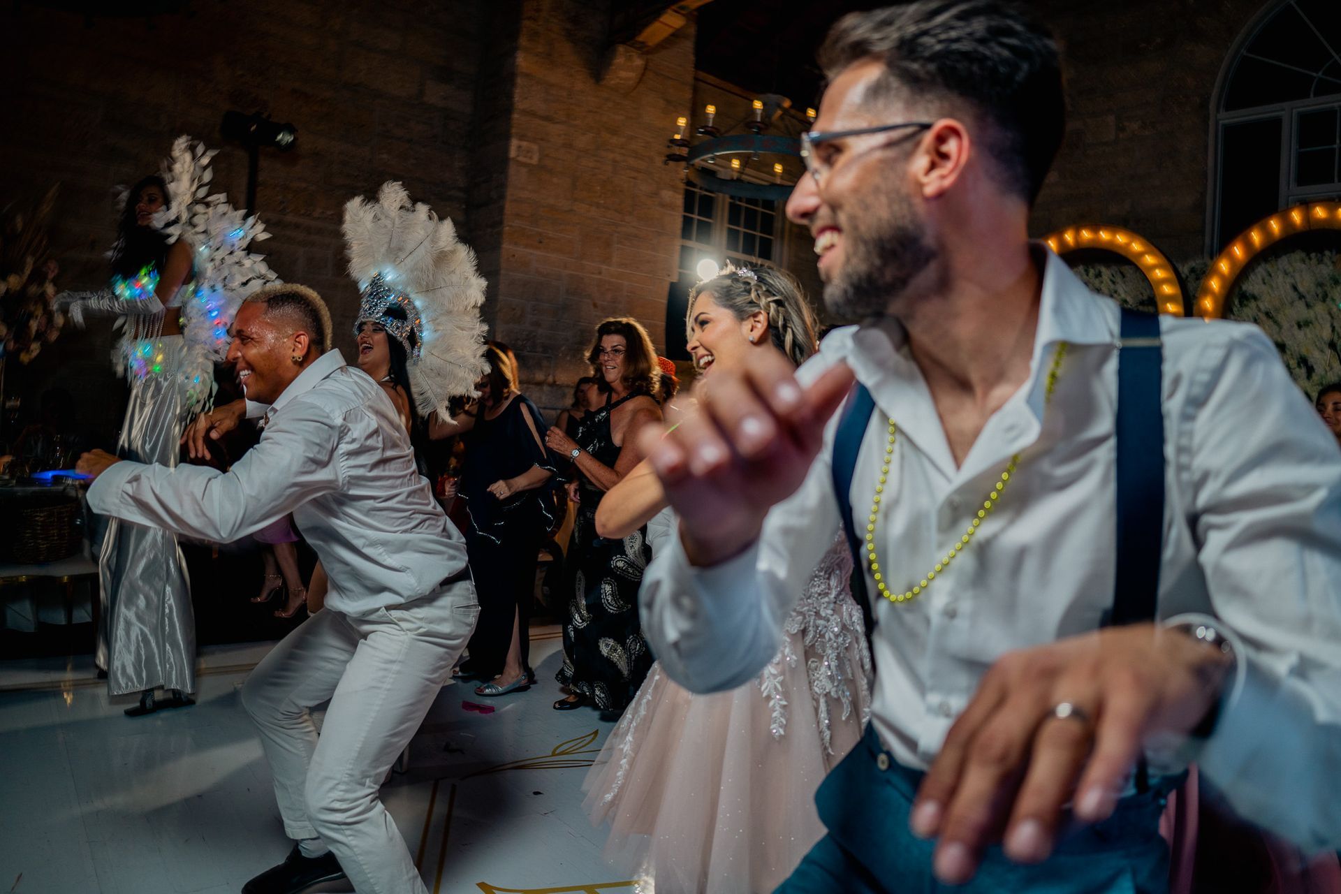A group of people are dancing on a dance floor at a wedding reception.