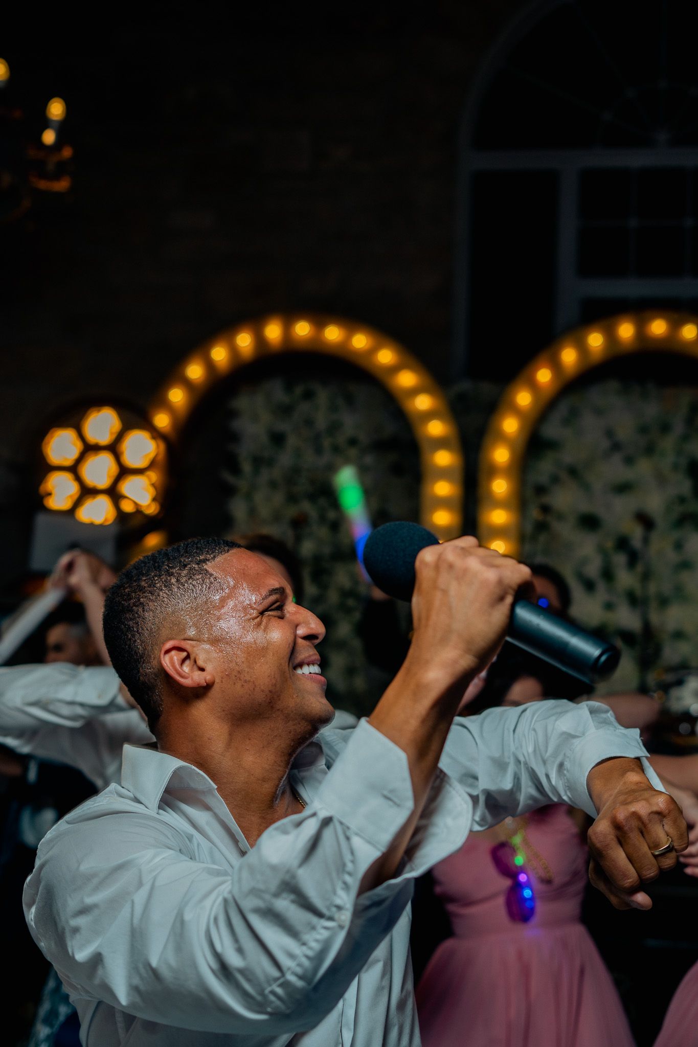 A man is holding a microphone in his hand while dancing at a party.