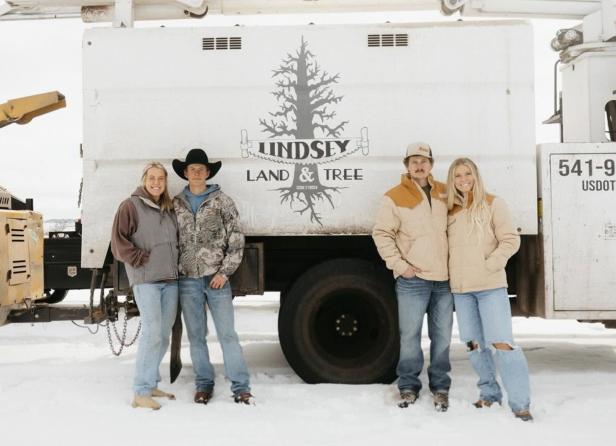 Tree service crew members in work gear near a ponderosa pine on a Central Oregon property