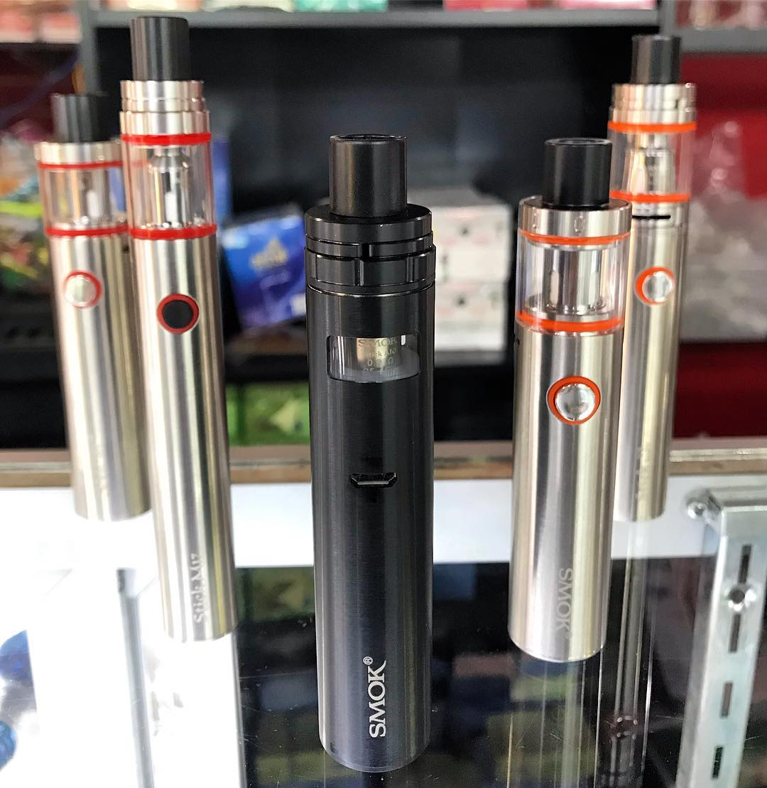 Three vape pens displayed on a counter, with black and silver finishes and red-ring details.
