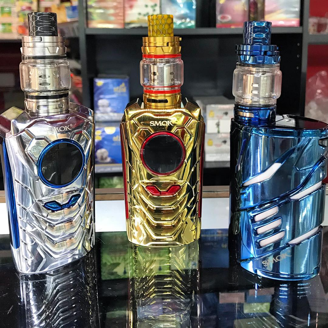 Three colorful mechanical vape mods in silver, gold, and blue on a store shelf.