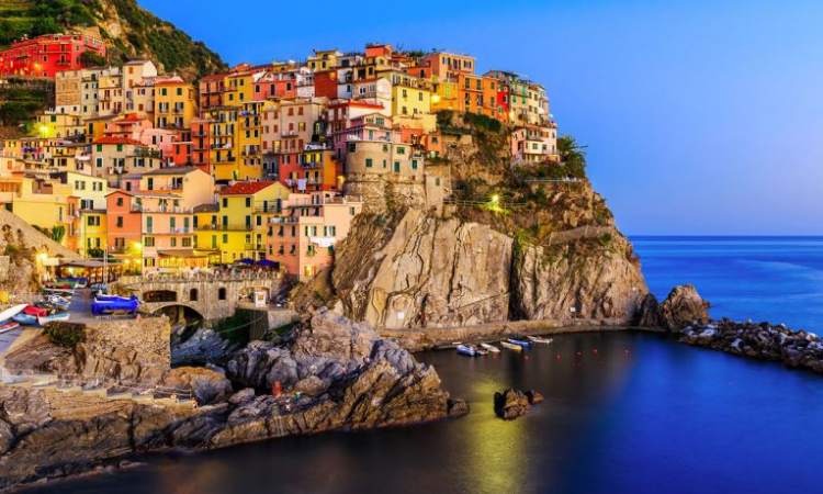 A small town on a rocky cliff overlooking the ocean.