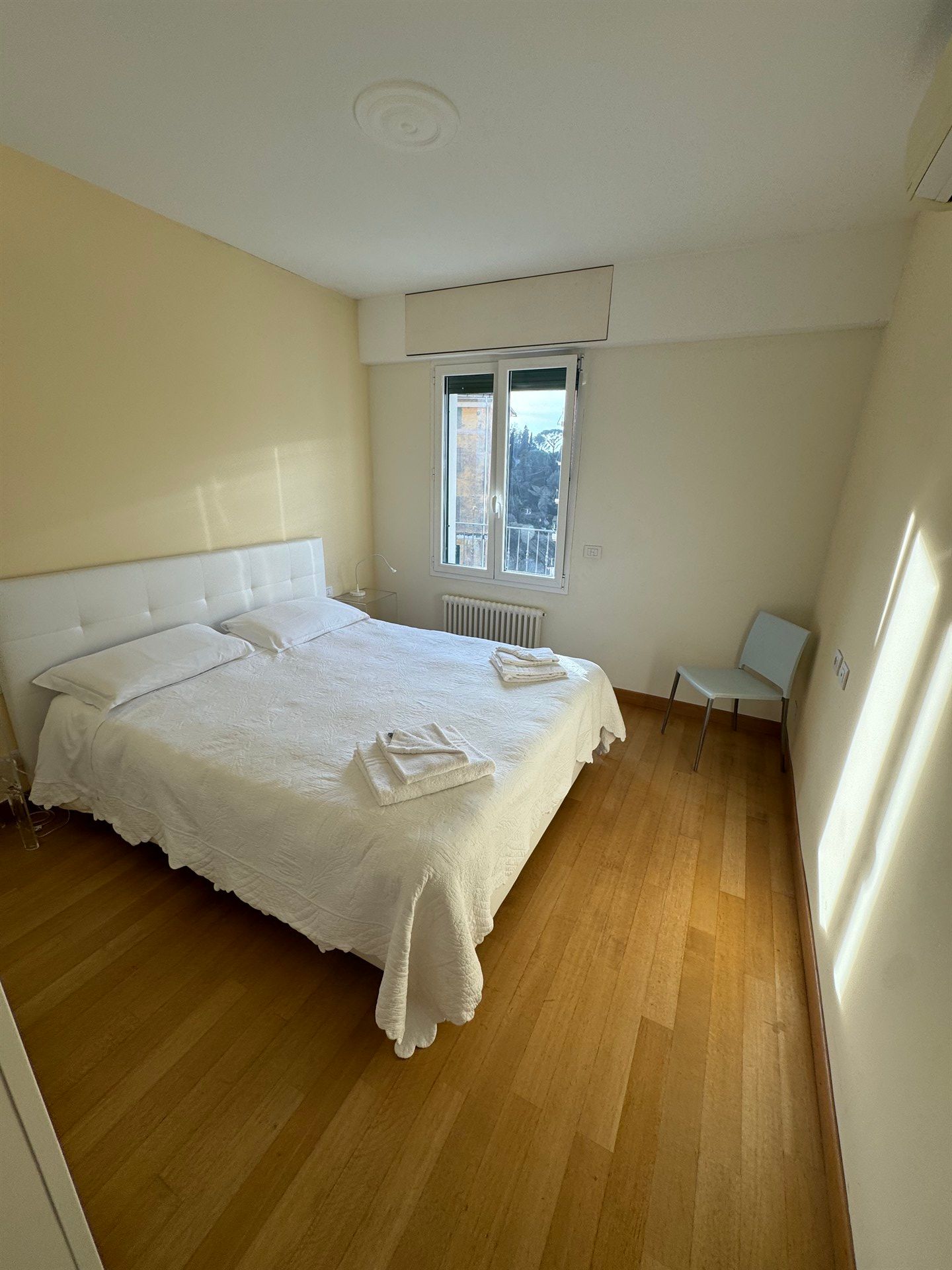 A bedroom with a bed , chair and window.
