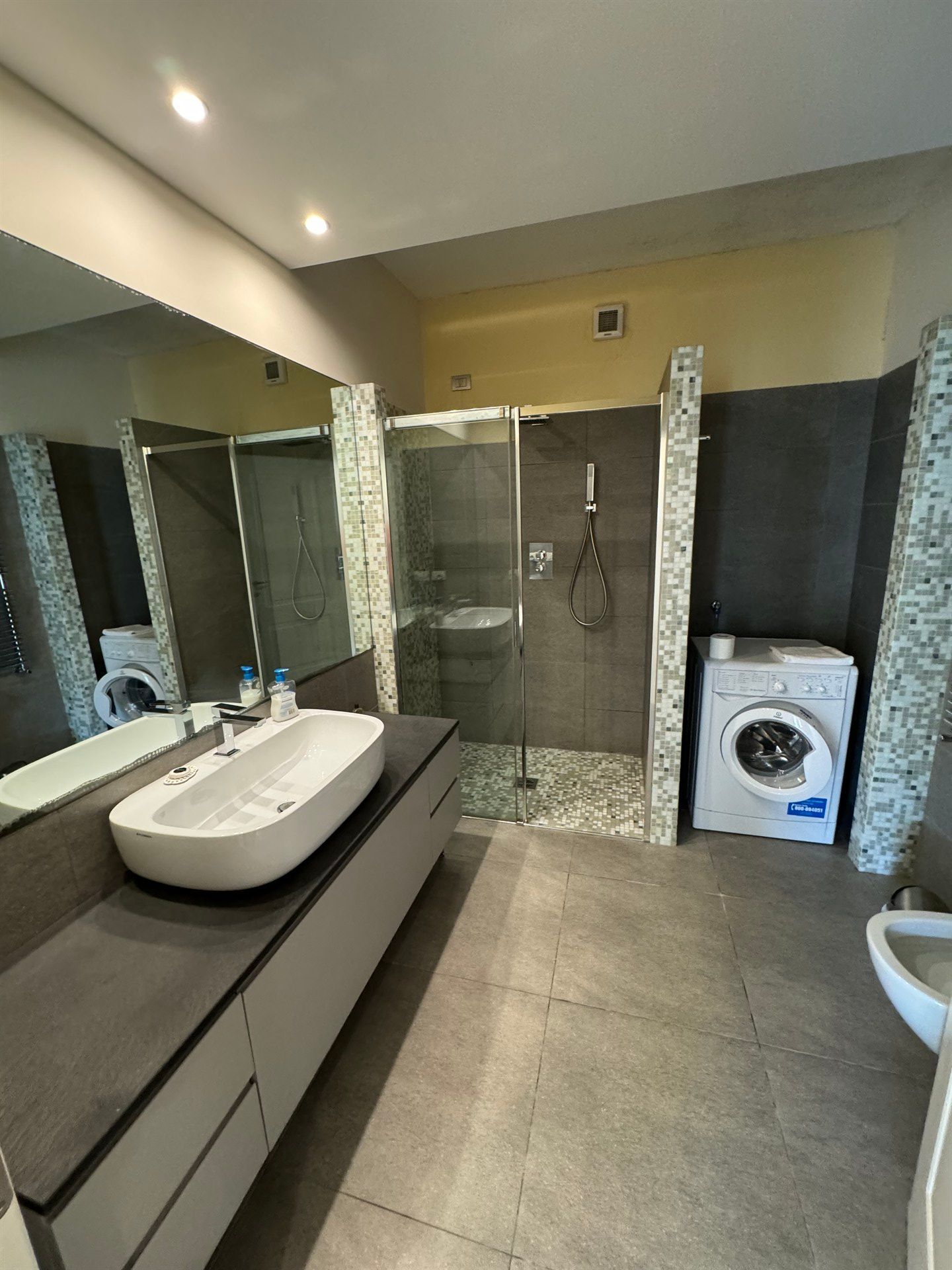 A bathroom with a sink , washer and dryer.
