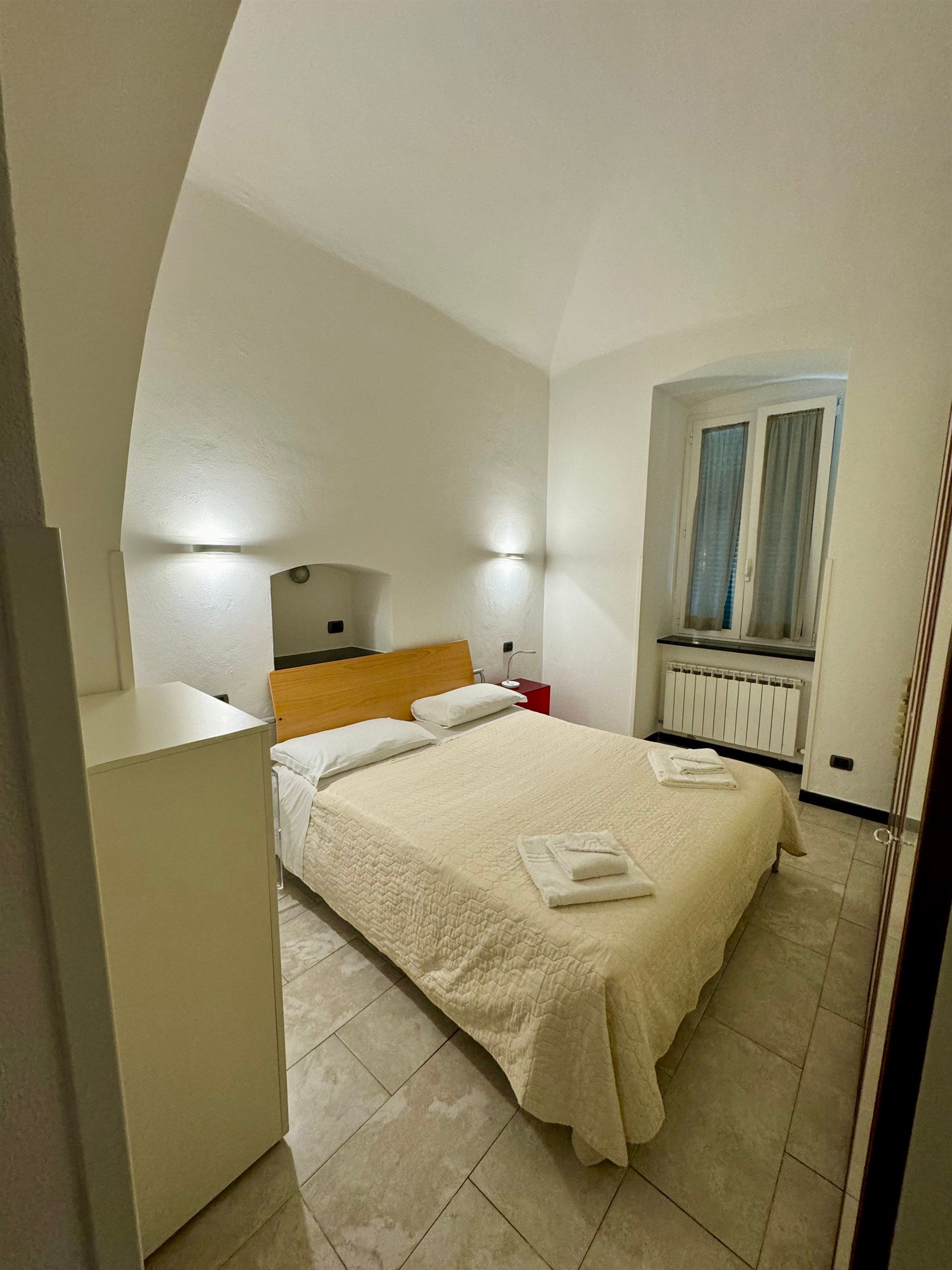 A bedroom with a large bed and a window