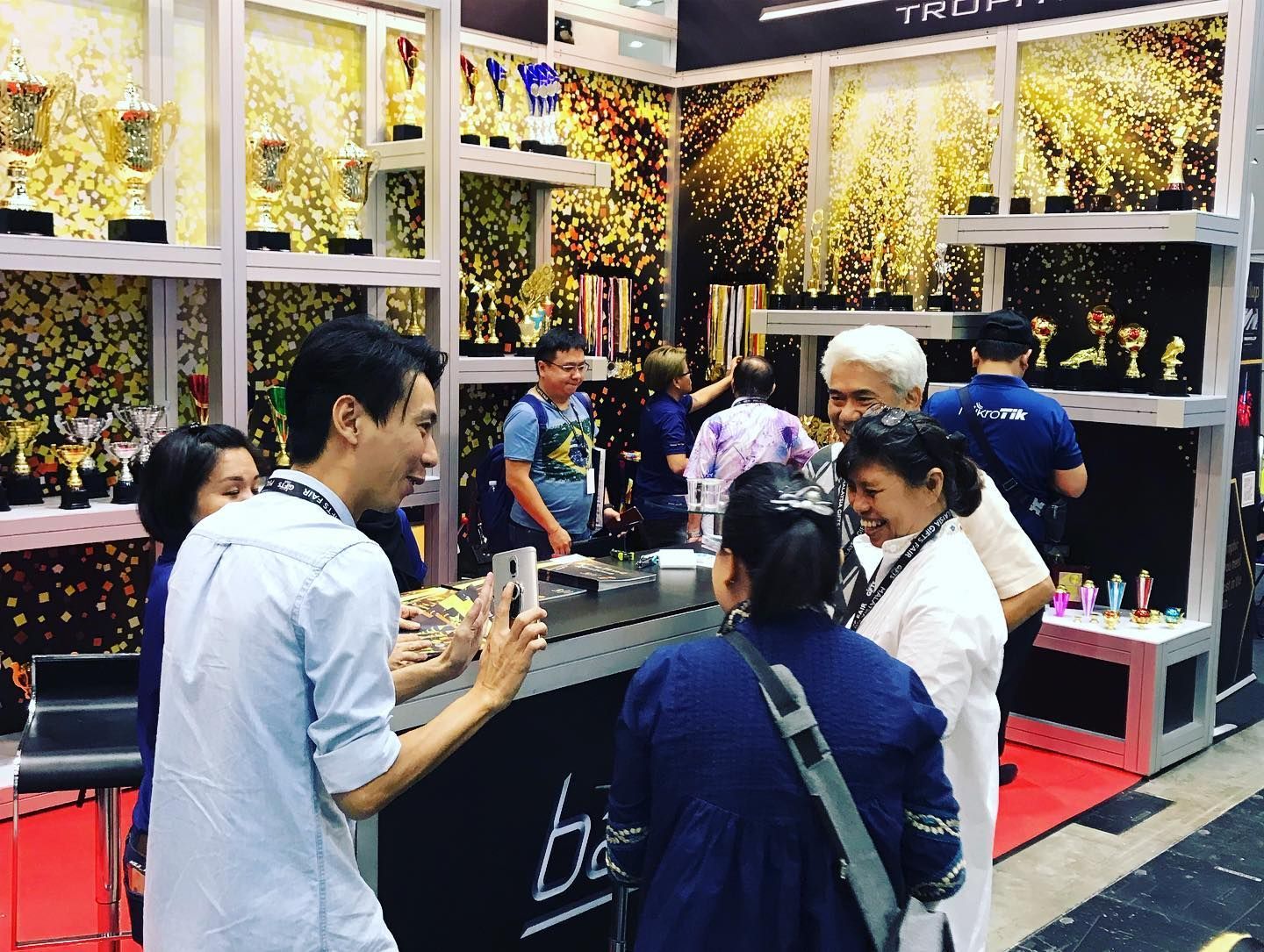 Sales team member talking to a customer at Baguss Enterprise booth during MGF 2019, KLCC — discussing products.