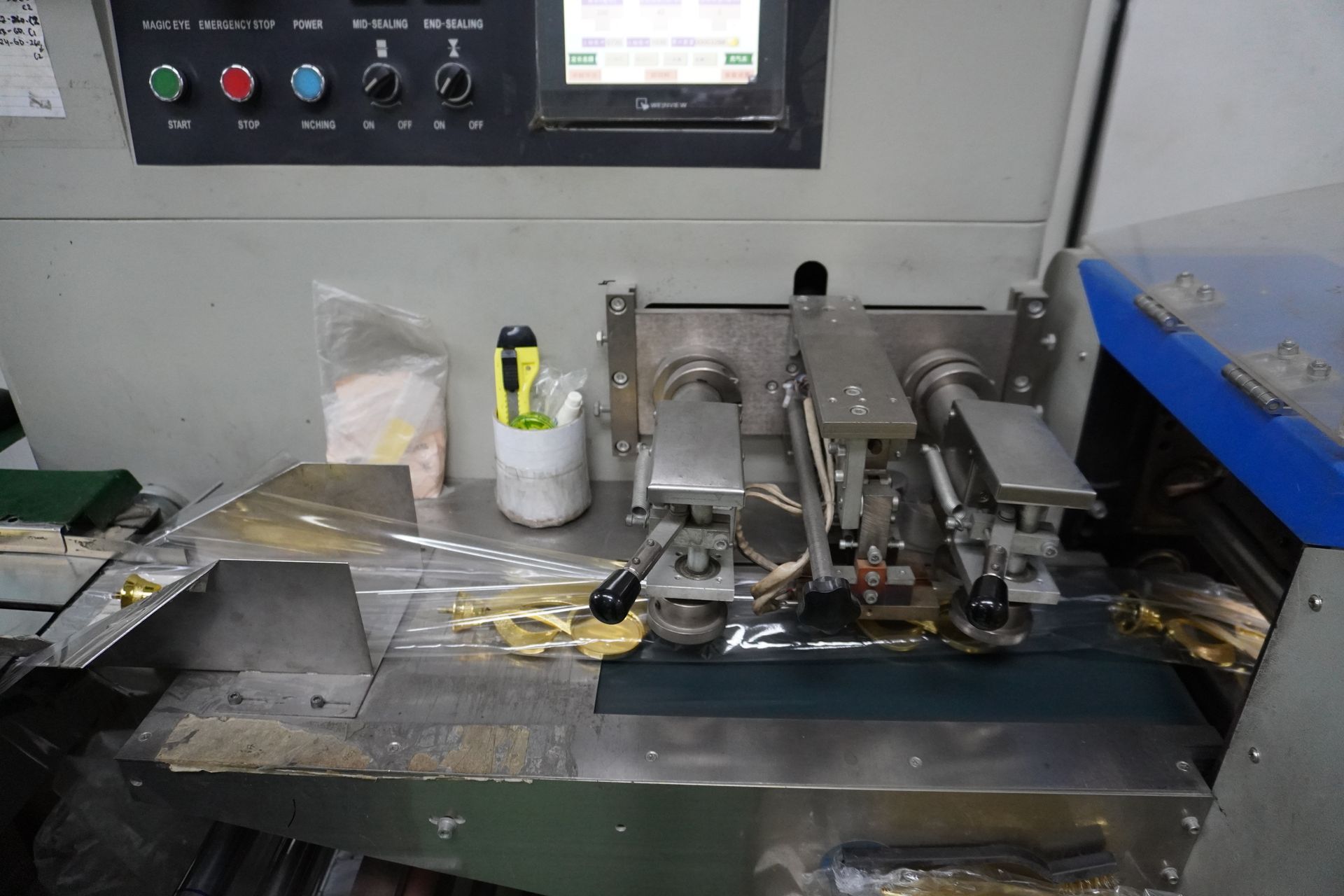 Machine automatically packaging trophy top holders one by one — streamlining production at Baguss Enterprise.