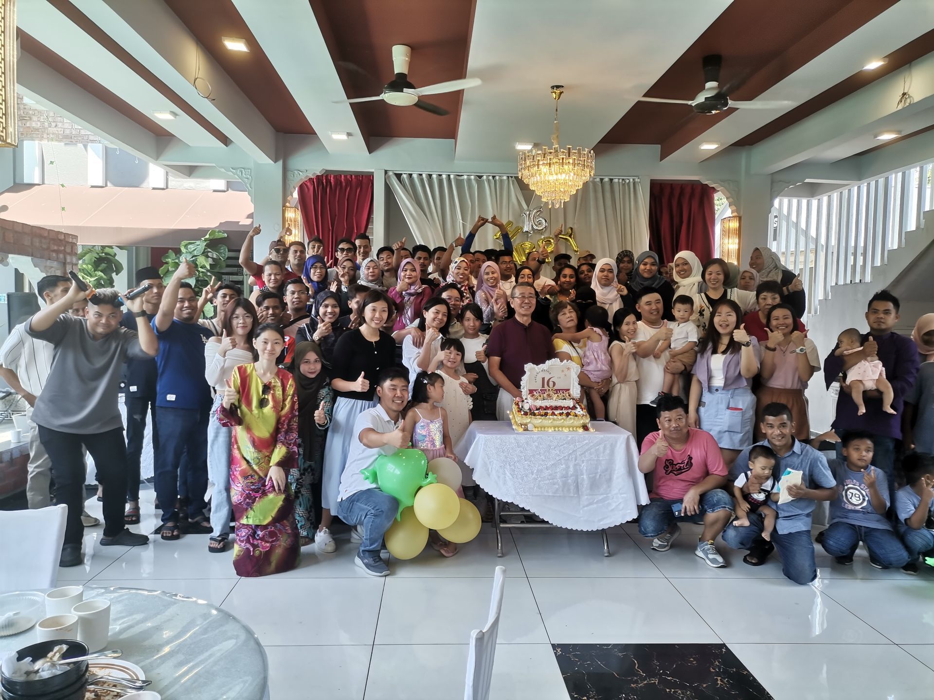 Group photo of staff with the boss during the 2024 Raya gathering at The Grand Mulia, celebrating together as a team.