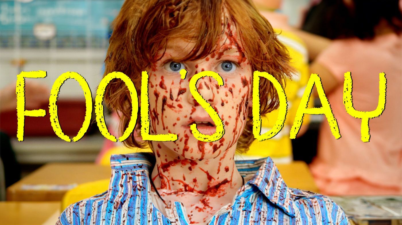 A person in a blue-striped shirt, face and neck splattered with red, stands in a classroom with the text FOOL'S DAY overlay.