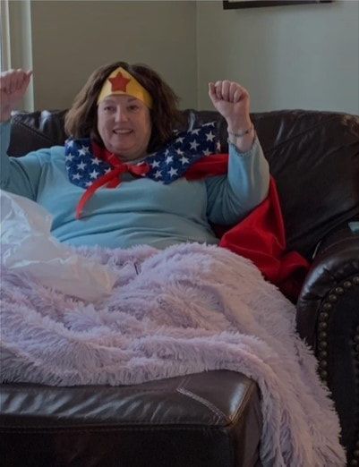 A woman in a wonder woman costume is sitting on a couch