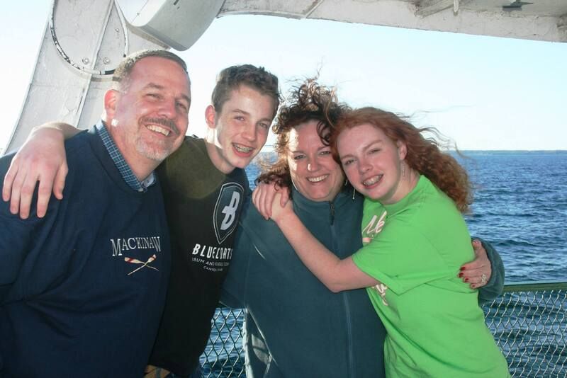 A group of people posing for a picture with one wearing a macomb shirt