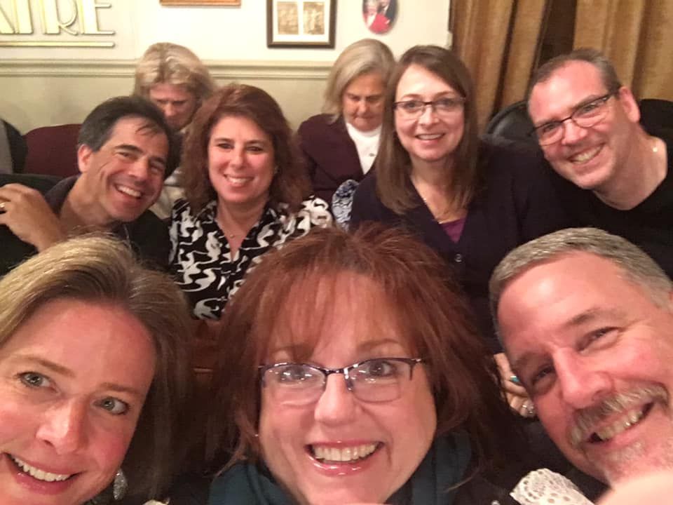 A group of people are posing for a picture together and smiling.