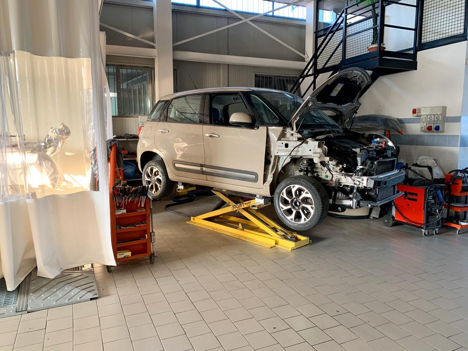 macchina in riparazione all'interno di un'autofficina
