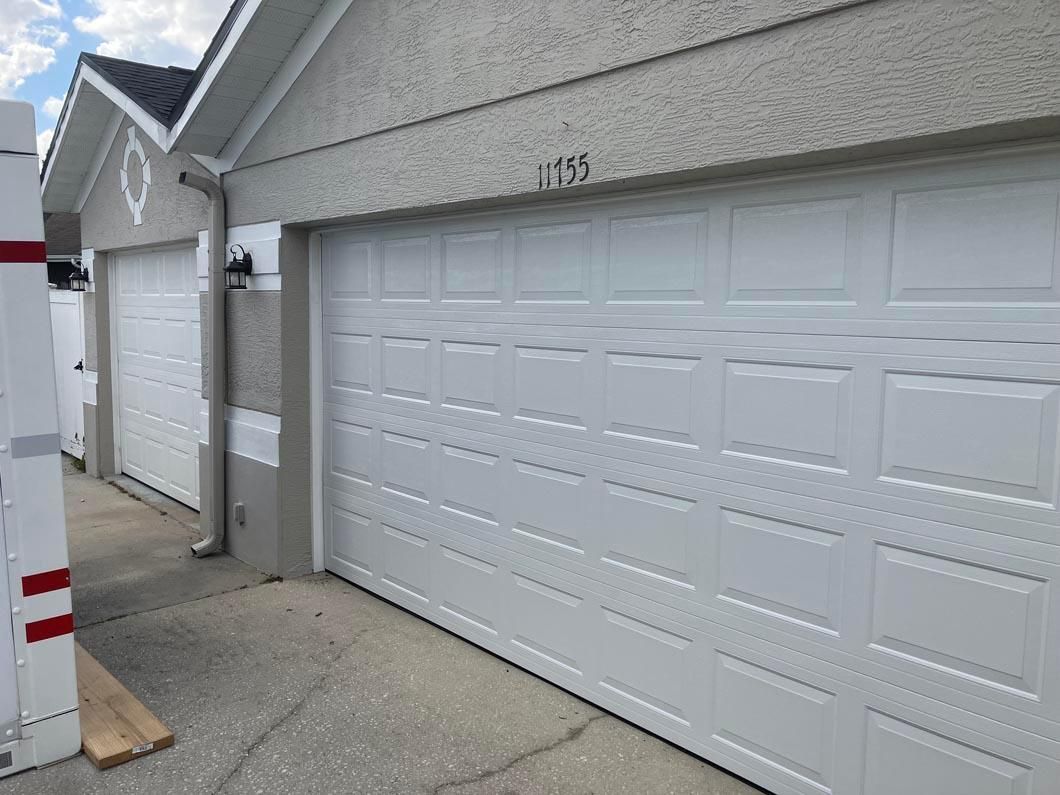 White garage doors along a concrete driveway in a residential alley, with house number 531 above one door