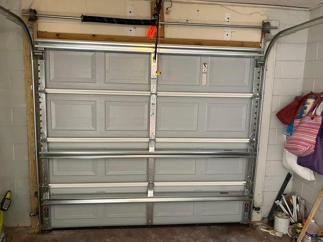 Closed gray garage door in a cluttered garage interior