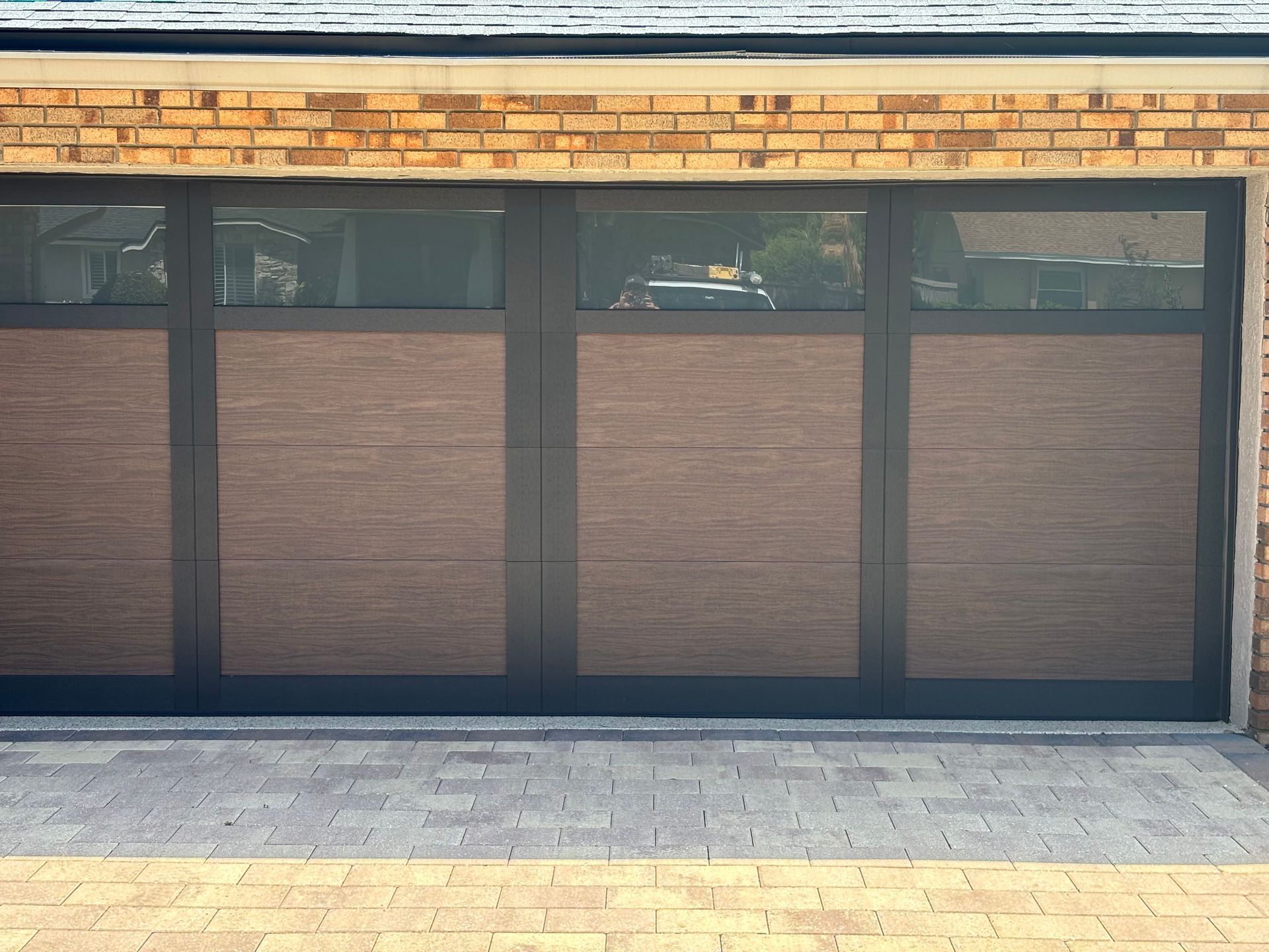 Closed storefront with dark framed glass doors and windows beneath a brick facade