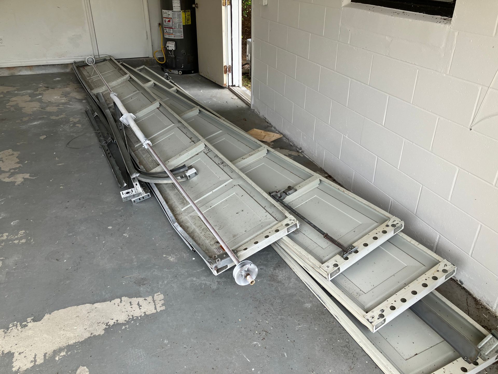 Folded metal ramp sections stacked along a wall in a garage-like room.