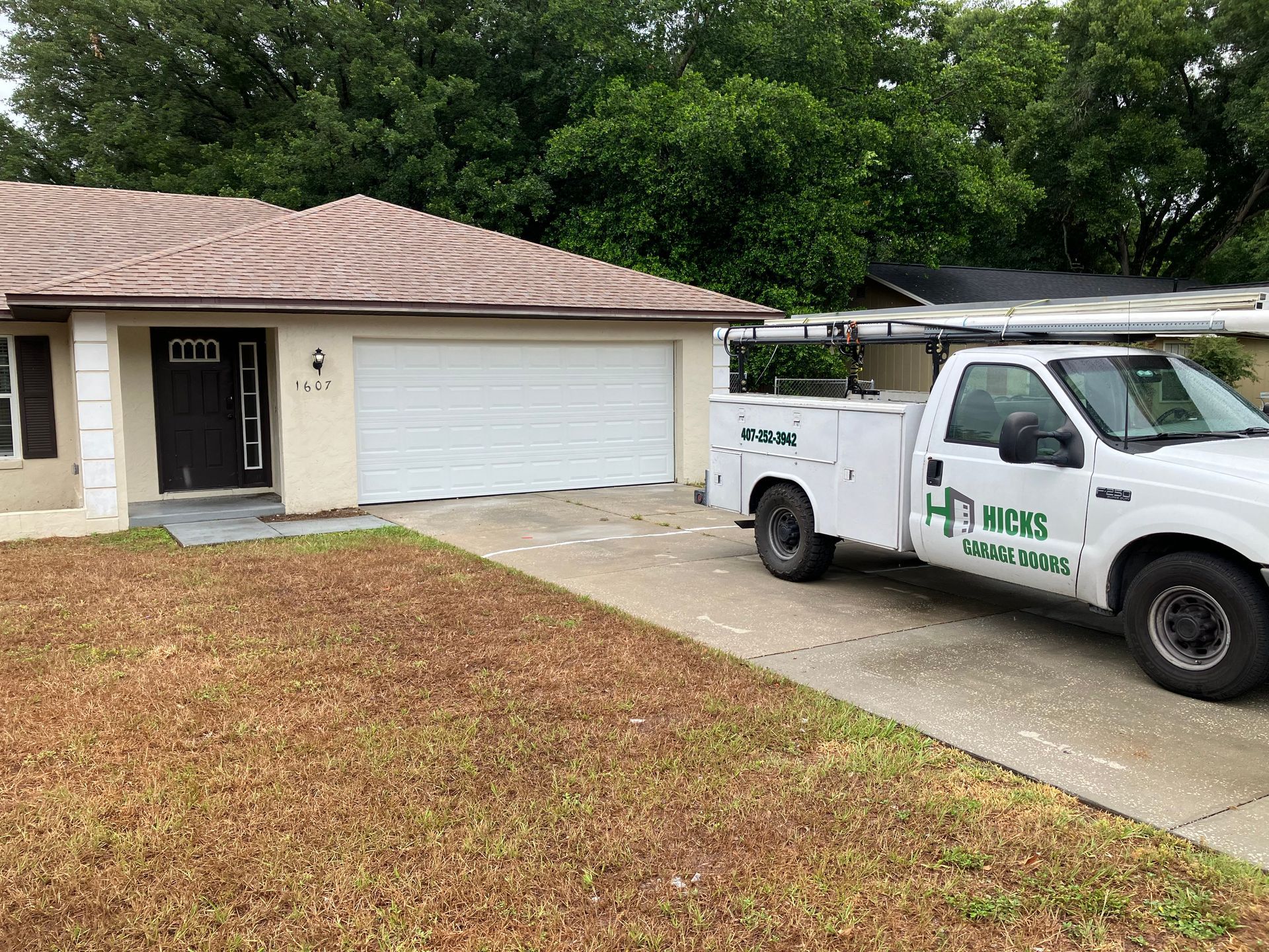 House exterior with garage and a white service truck parked in the driveway.