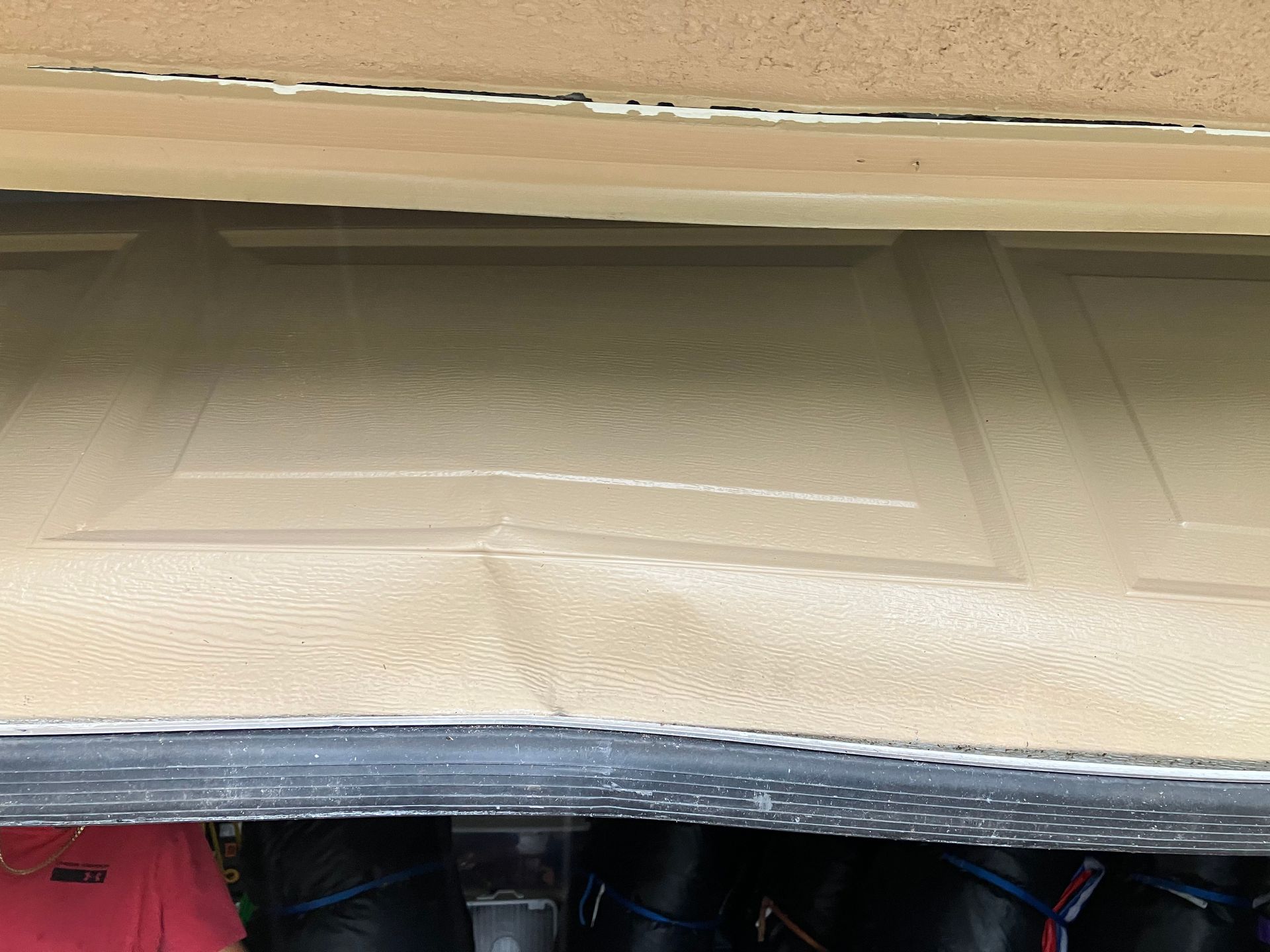 Beige mattress topper under a wooden bed frame with storage bins visible below.