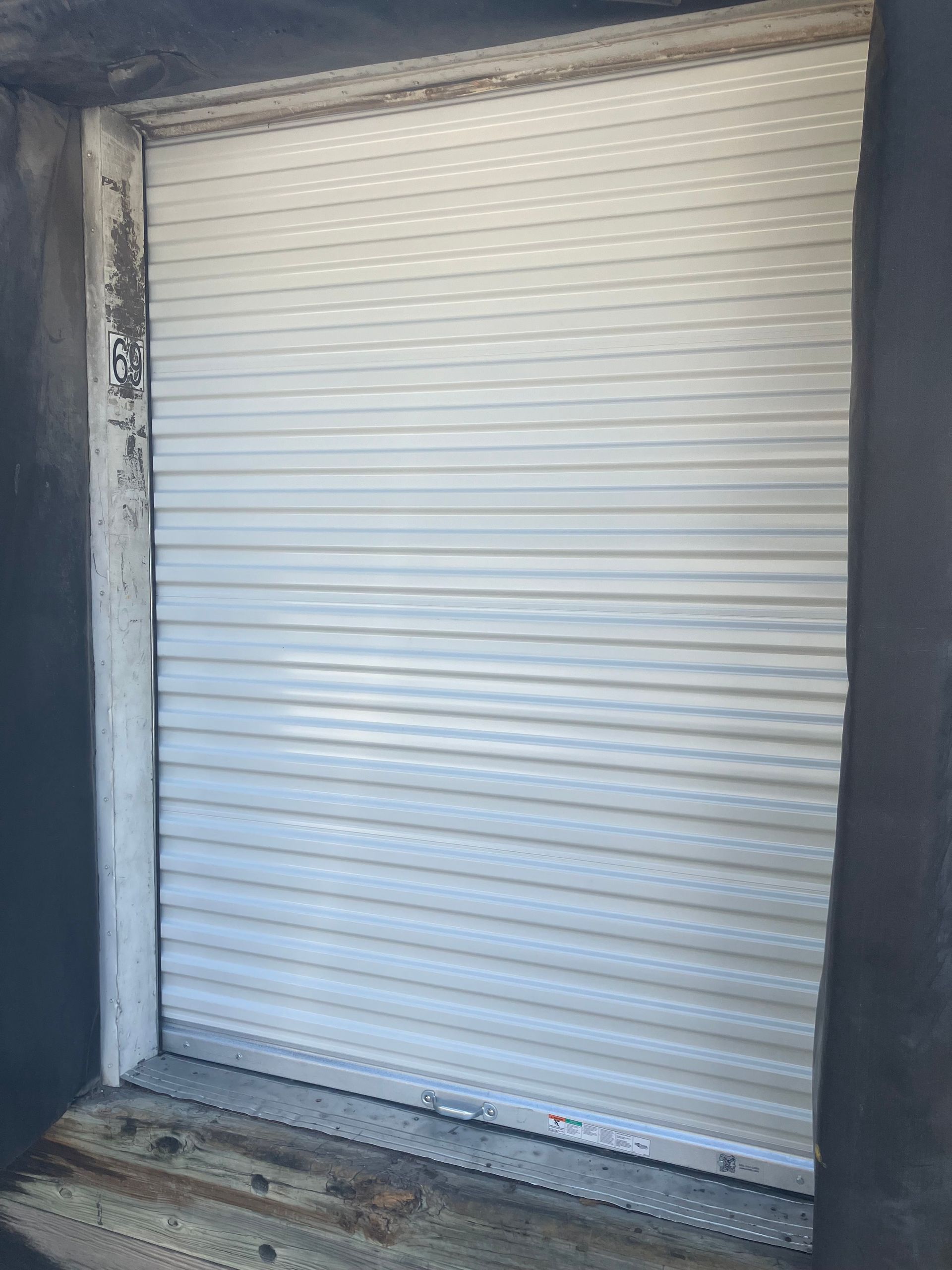 Closed white roll-up garage door in a dark concrete doorway