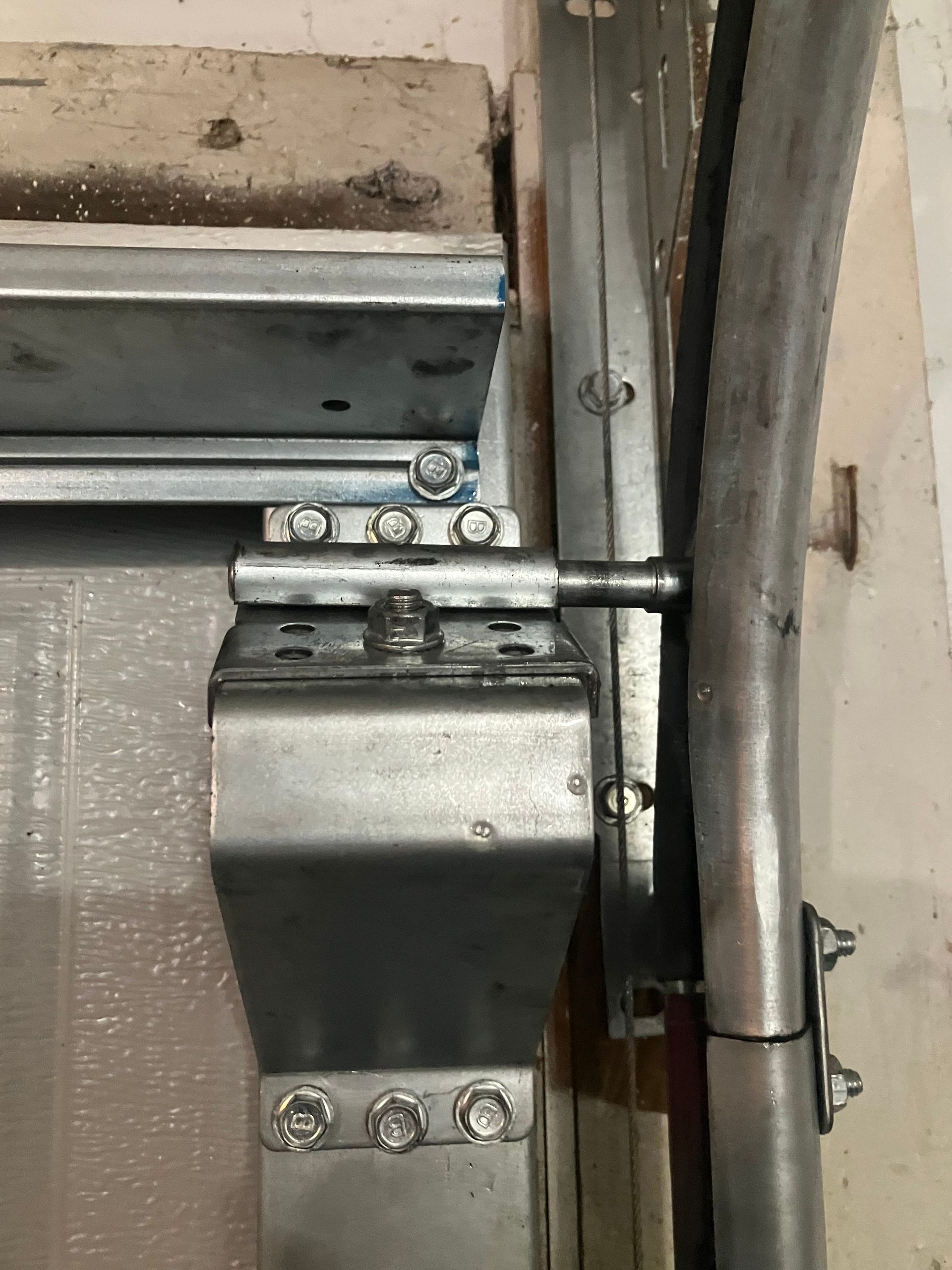 Close-up of a metal door hinge and latch mechanism mounted on a wall