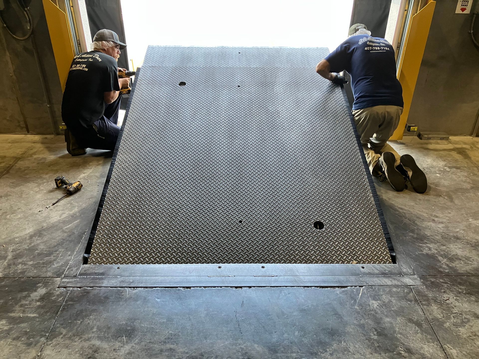 Workers installing a metal accessibility ramp at a building entrance