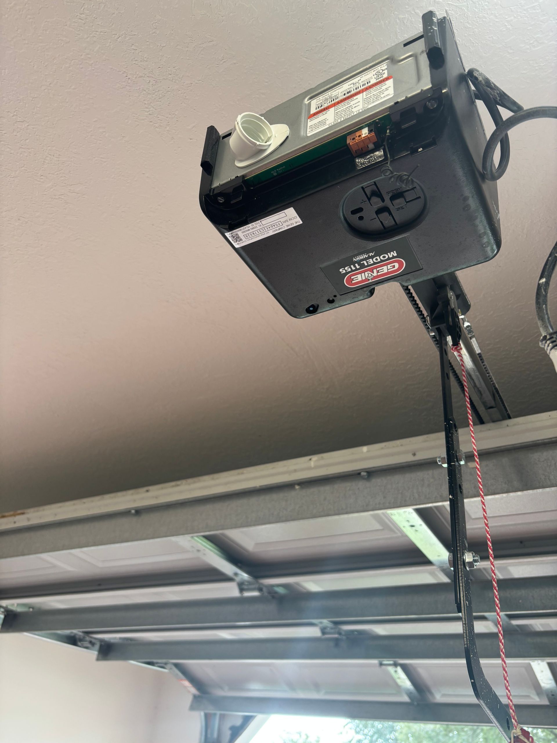 Ceiling-mounted garage door opener above an open garage door
