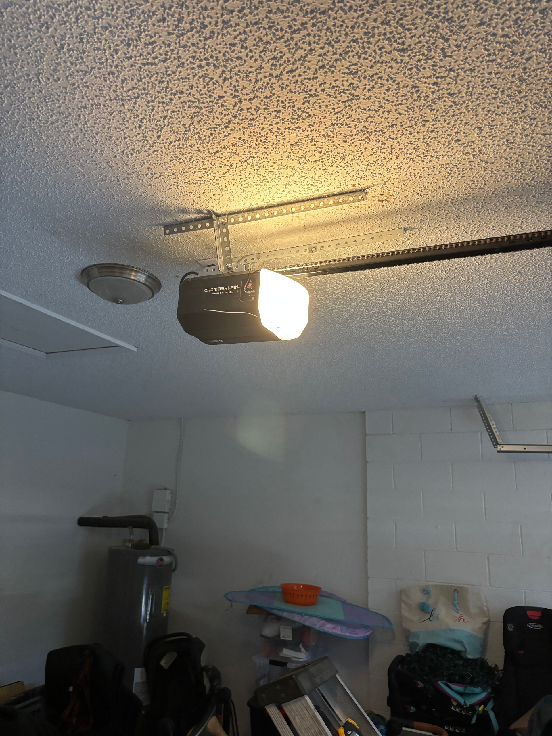 Ceiling-mounted light fixture glowing in a cluttered room with boxes and household items below