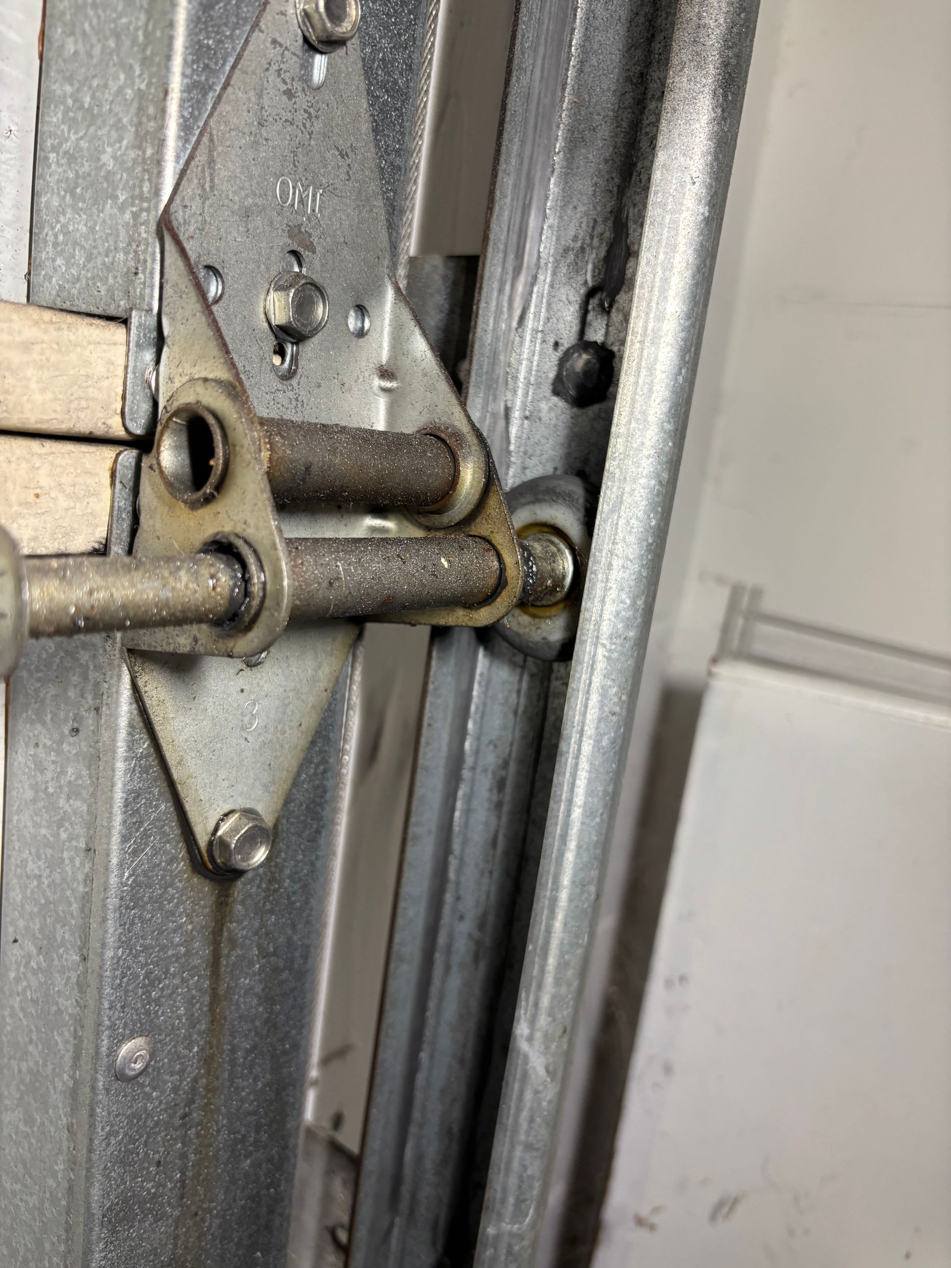 Close-up of a brass spring-loaded latch and metal hardware on a door or gate edge.