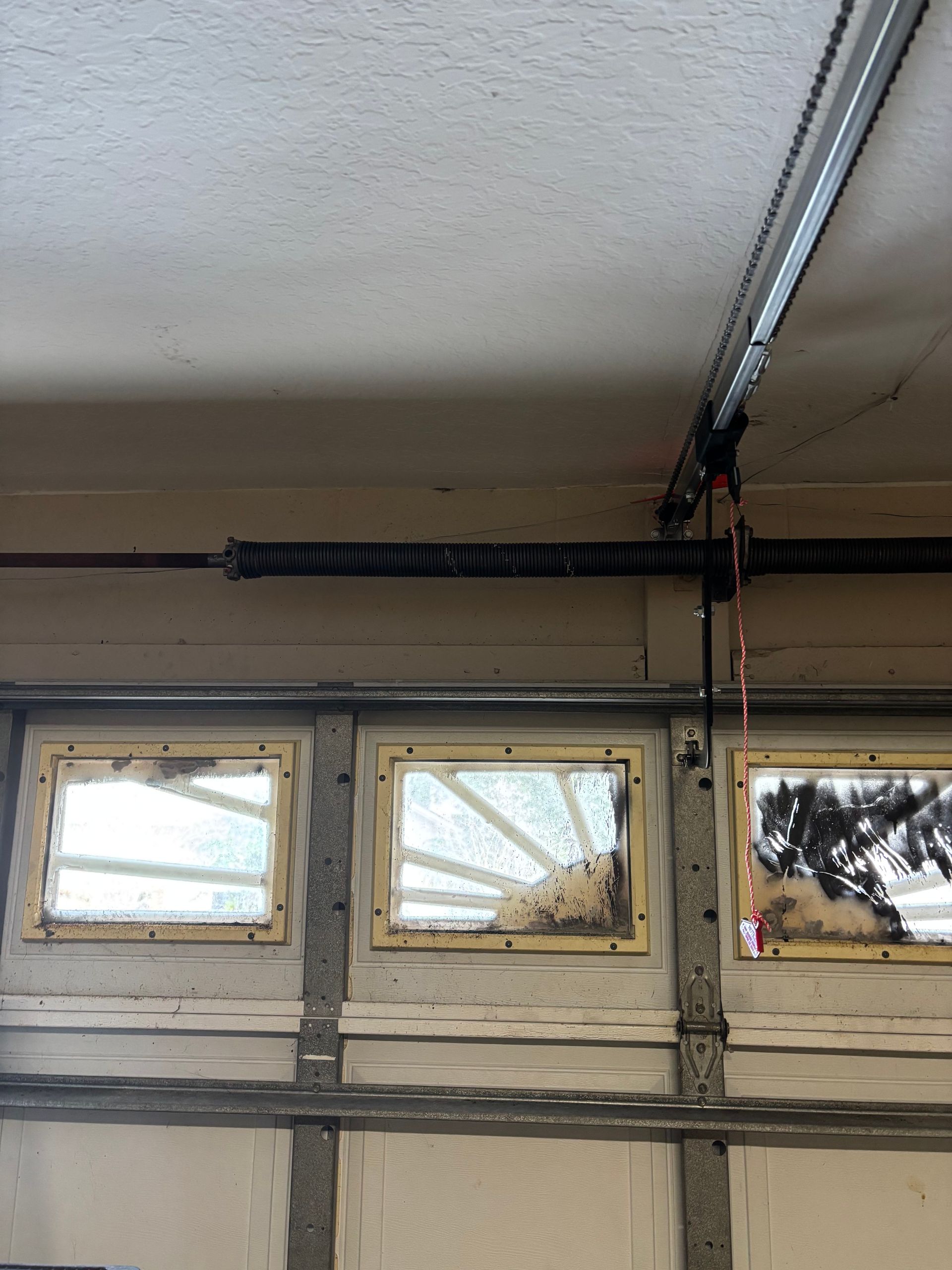 Garage interior with three small windows and an overhead garage door rail on the ceiling
