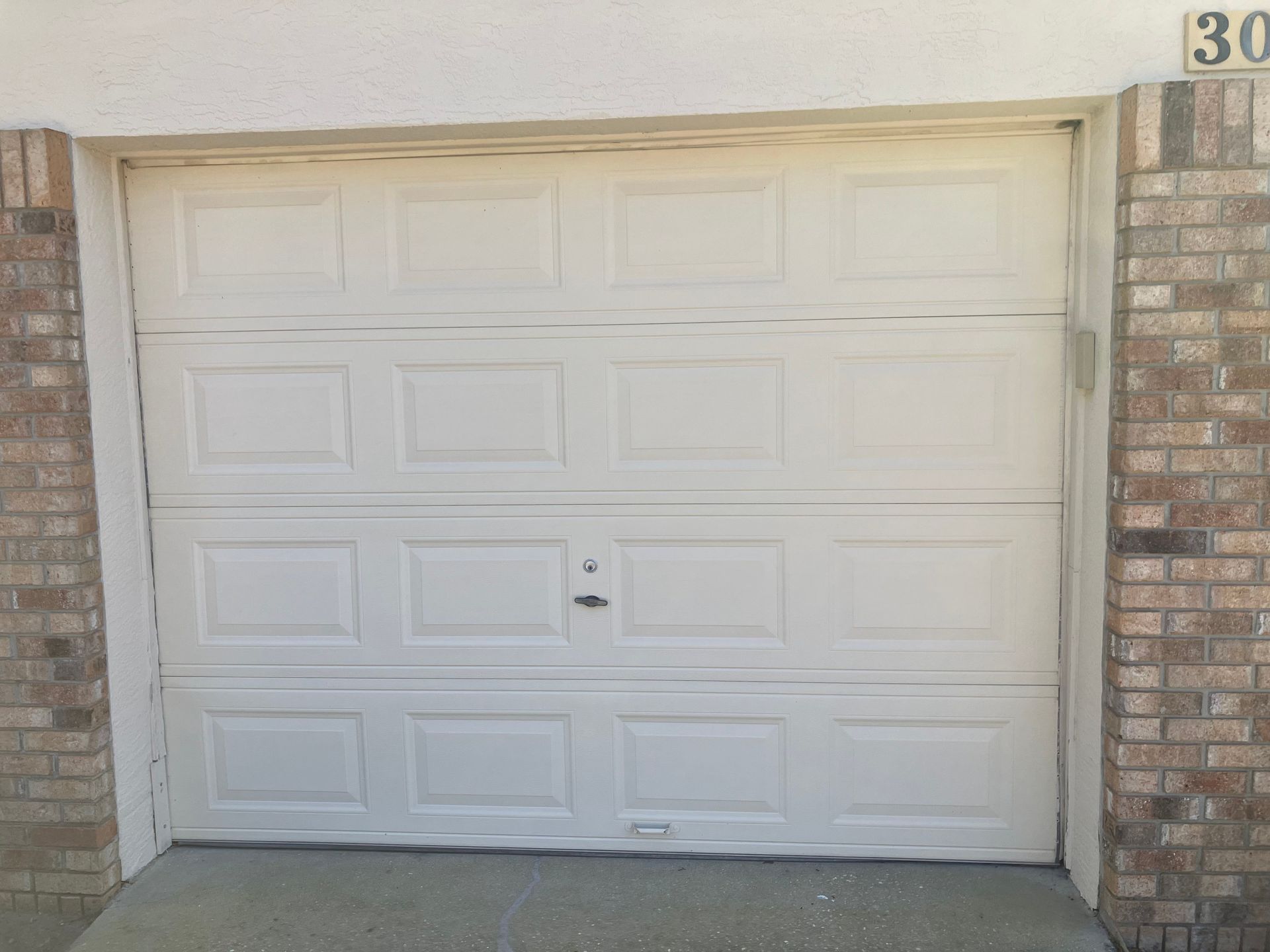 White garage door on a brick house exterior