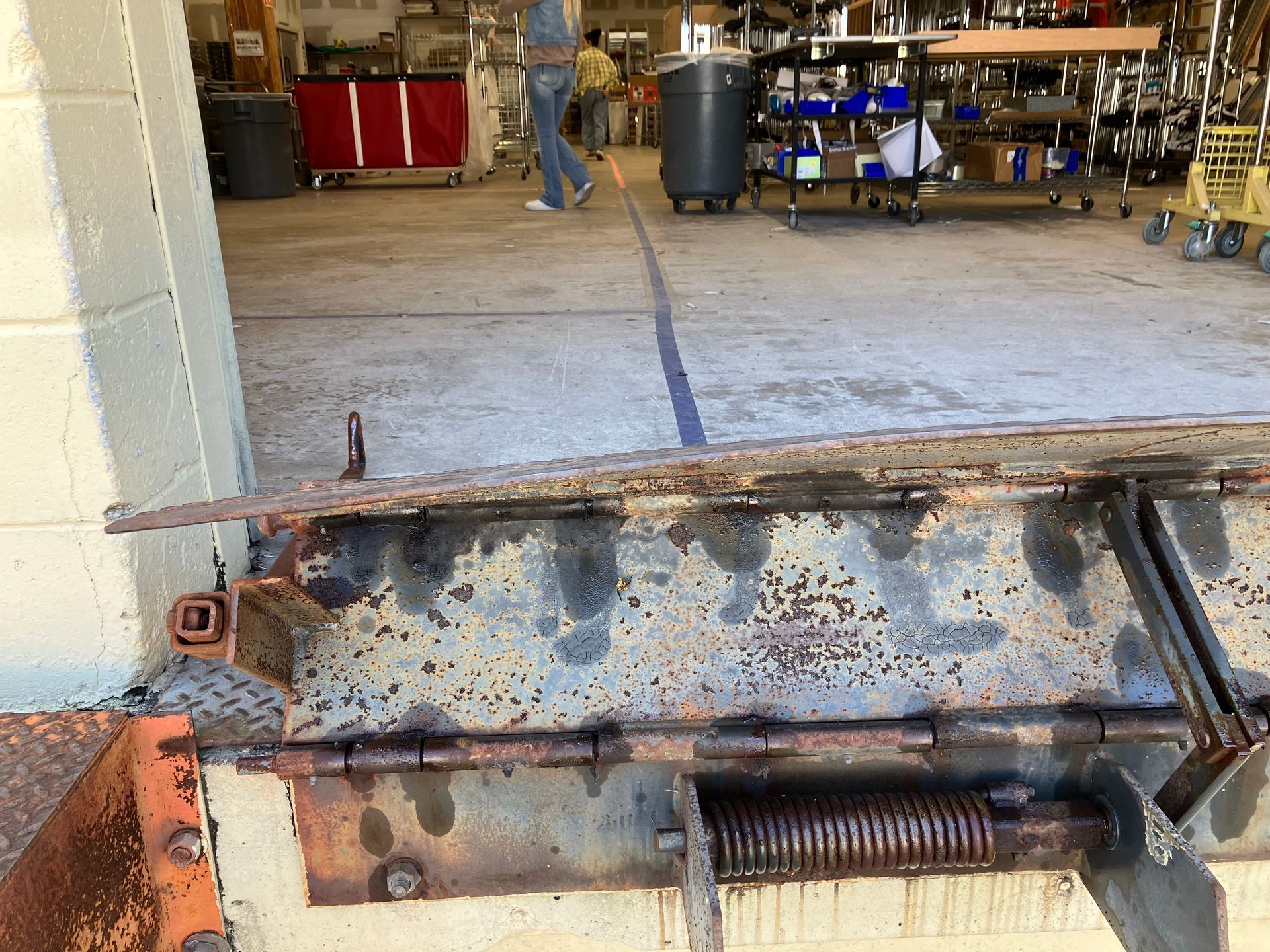 Rusty metal machine part in a workshop, with shelves and tools in the background