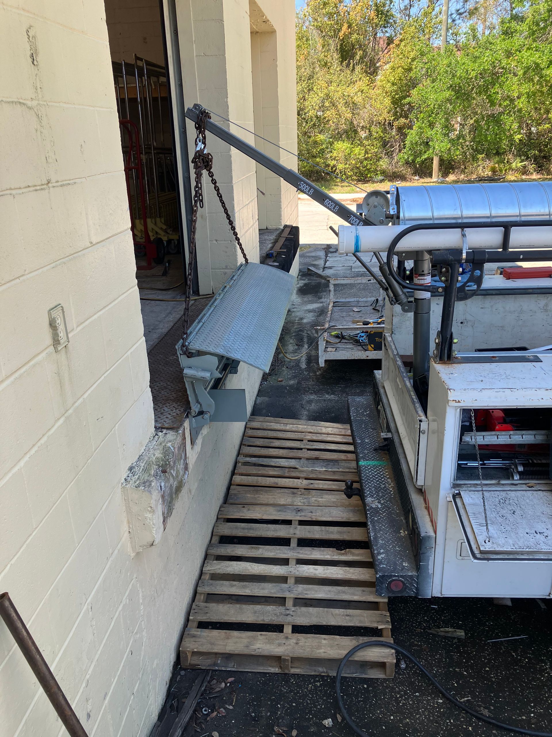 Portable lift platform and ramp beside a building entrance for wheelchair access