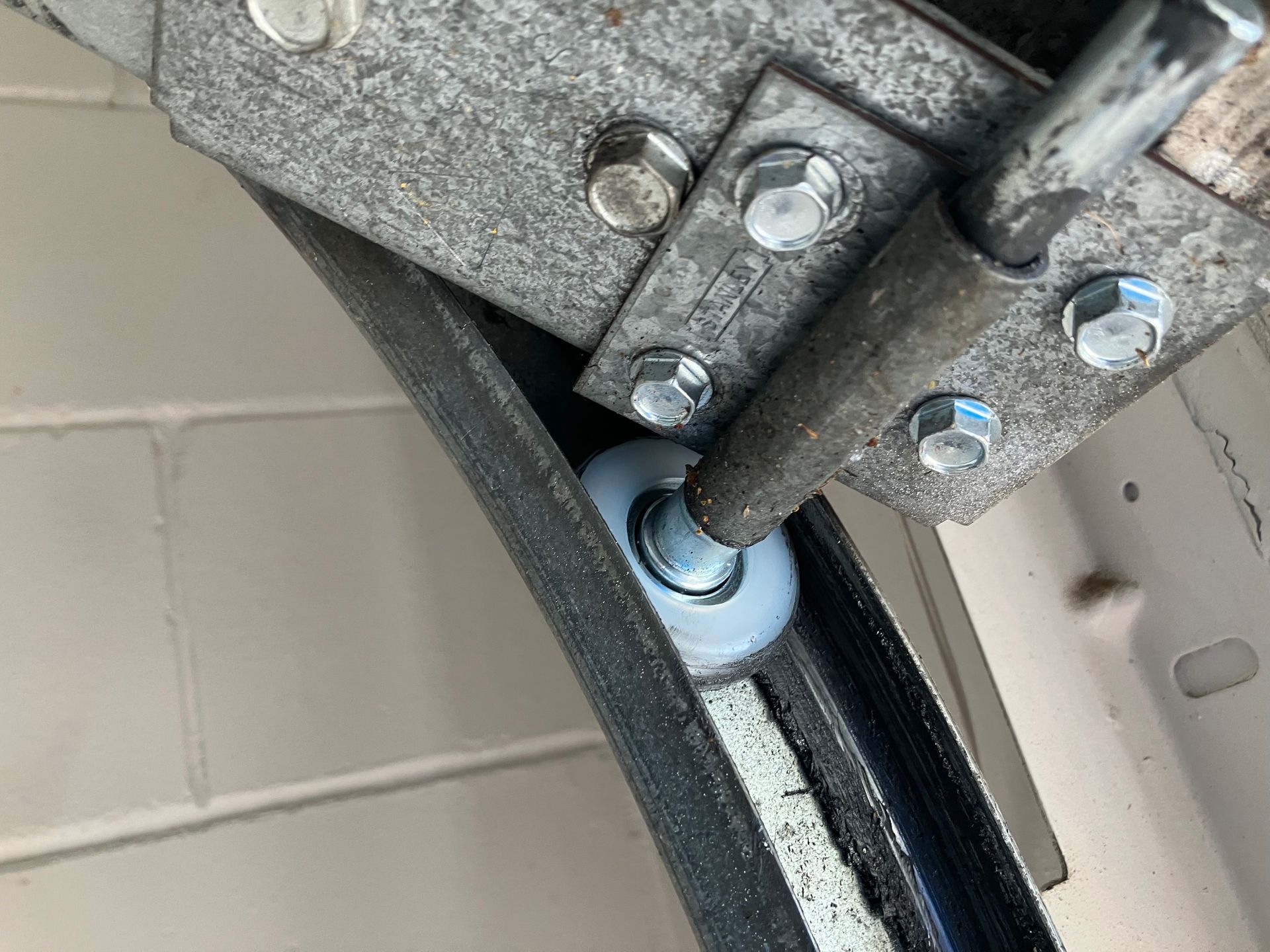 Close-up of a metal belt pulley and bracket assembly inside a machine.