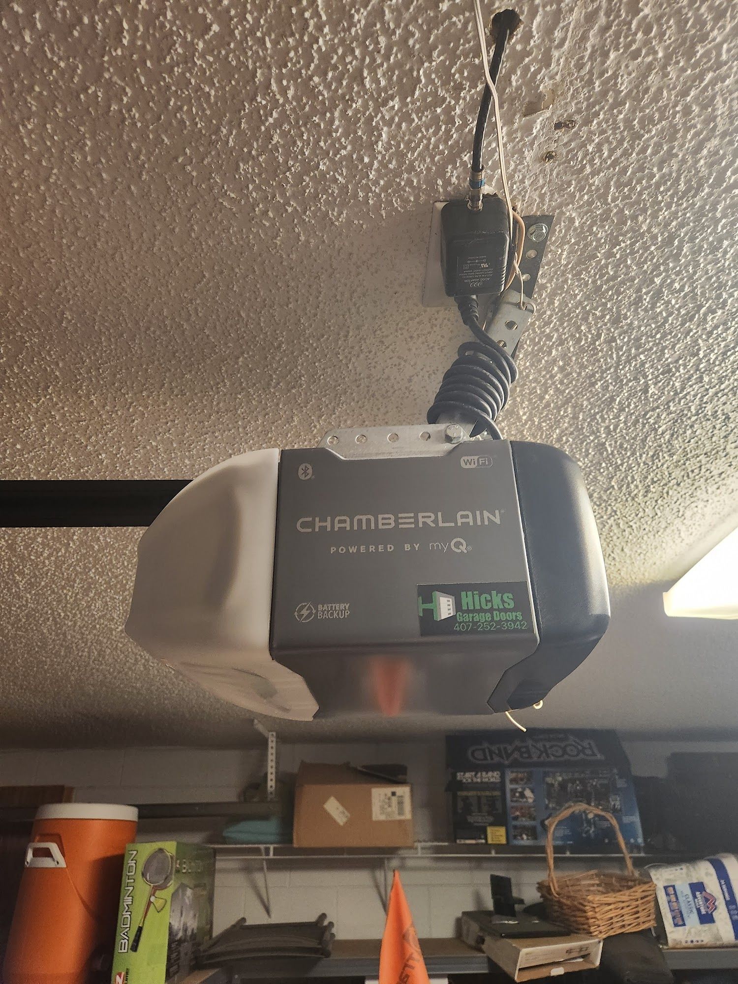 CHATEAU LARIA garage door opener mounted on a textured ceiling above storage shelves
